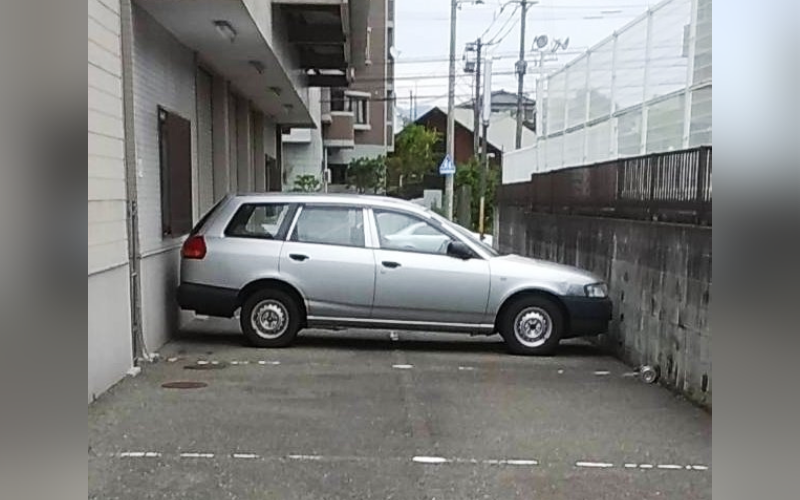 日本網友在推特上傳一張奇特的停車景象，不解地詢問怎麼停的，引發網友各種腦洞大開的回應。（翻攝推特@HAGE_TORA_CMR）