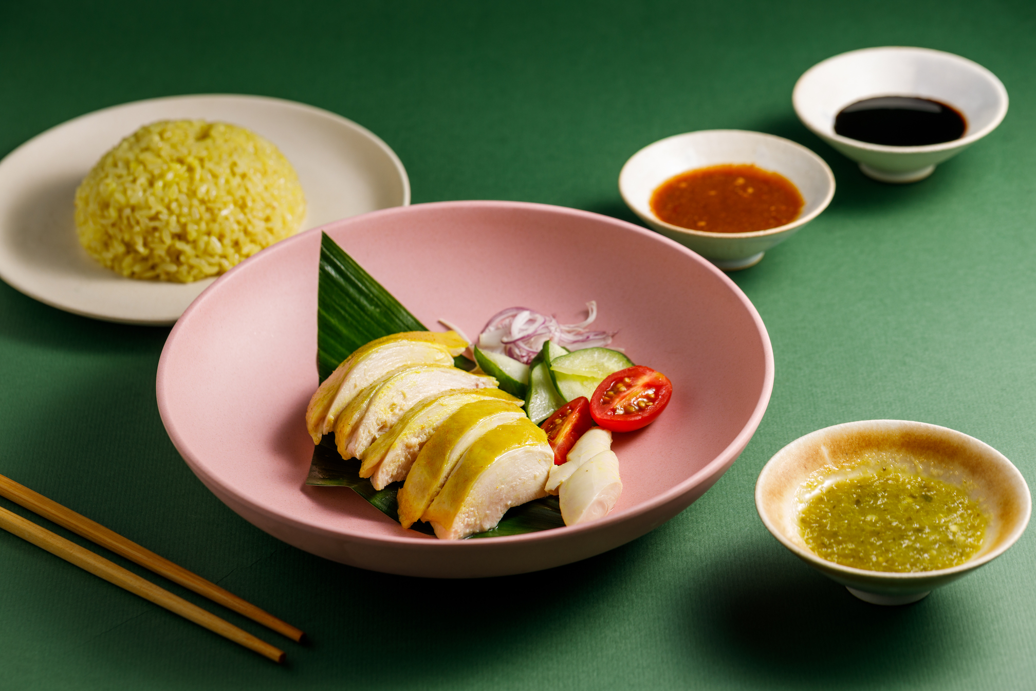 雞王「海南雞飯」雞肉嫩滑，配上雞高湯悶煮的飯與三種醬料。（198元／份）