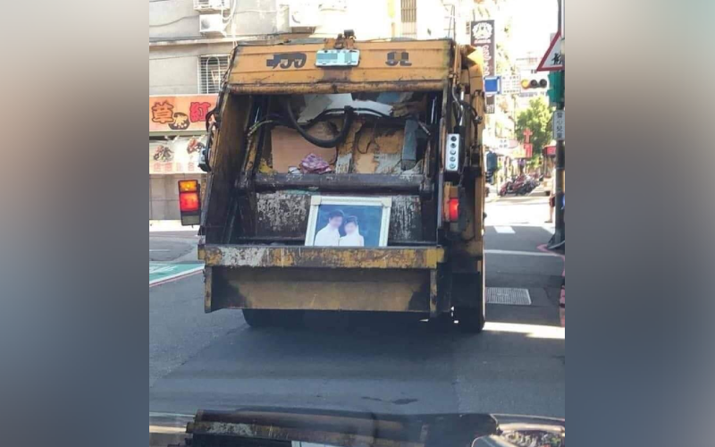 垃圾車放垃圾的車斗裡，擺放一面超大錶框婚紗照，許多網友分享自己經驗，覺得婚紗照最後可能變成浪費錢又難處理的尷尬紀念品。（翻攝IG@samantha829）