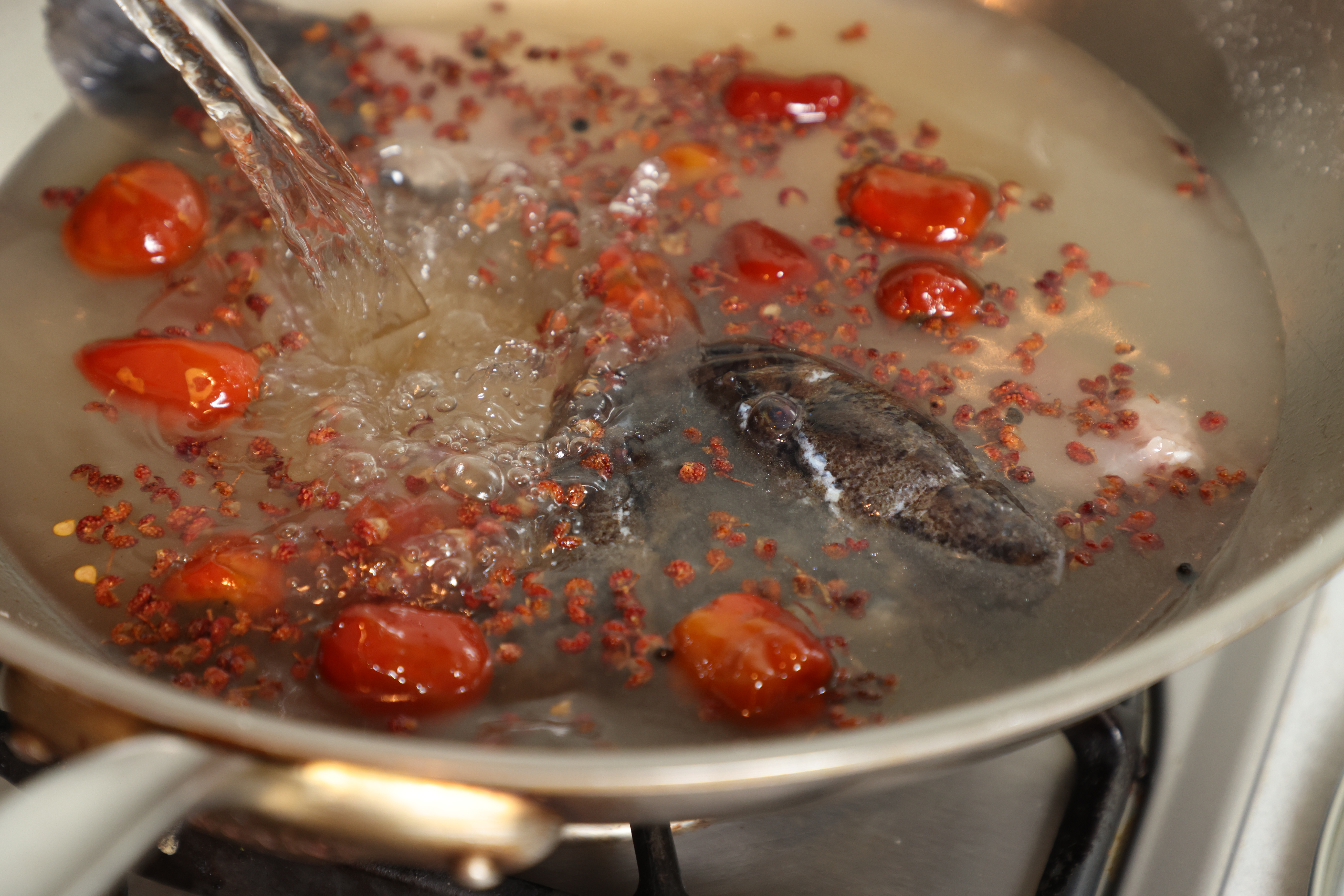 放入魚頭、魚骨，小火煨煮。