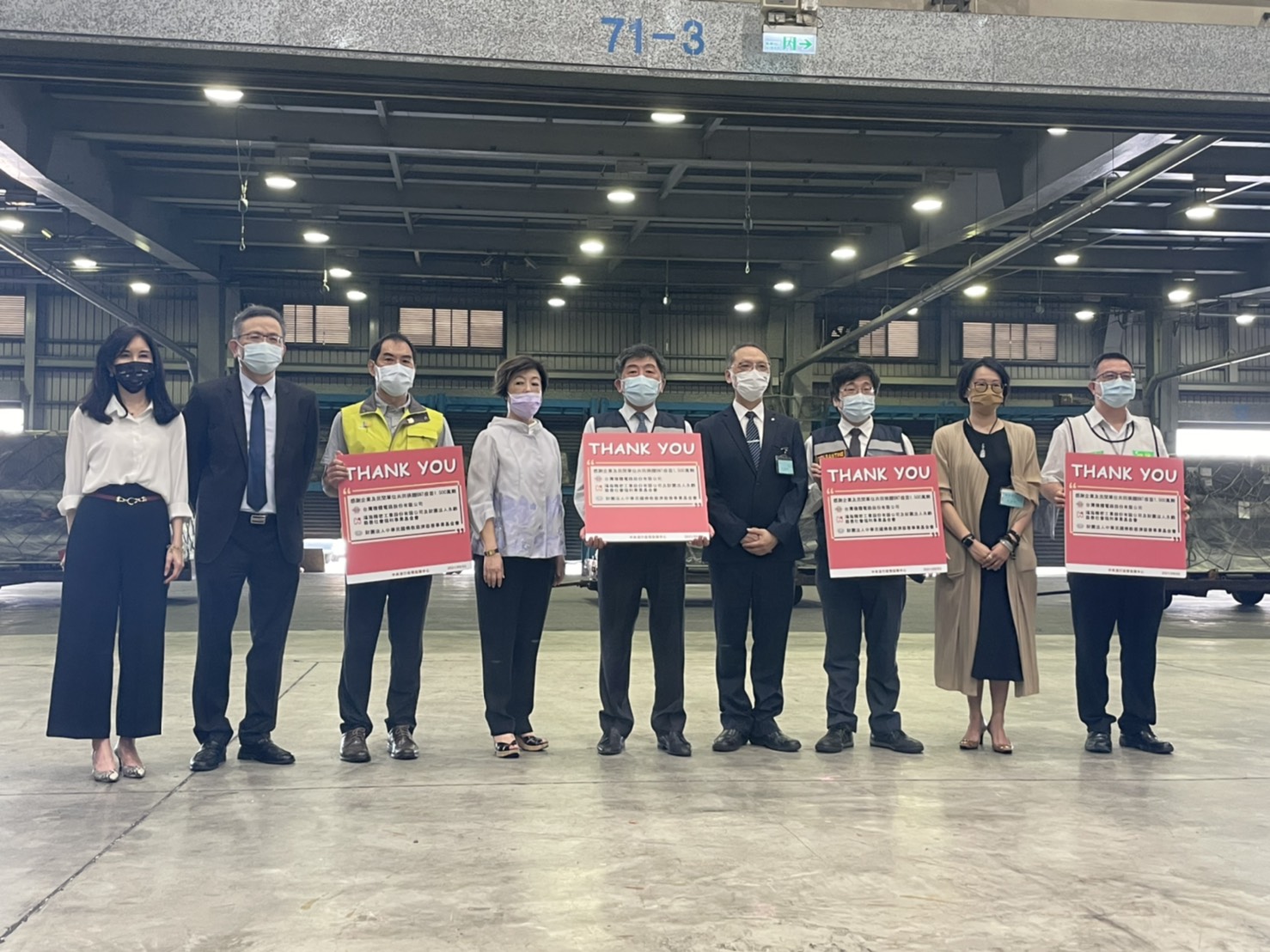 衛福部長陳時中（中）拿著「Thank You」字卡接機，感謝民間捐贈單位。（台積電基金會提供）
