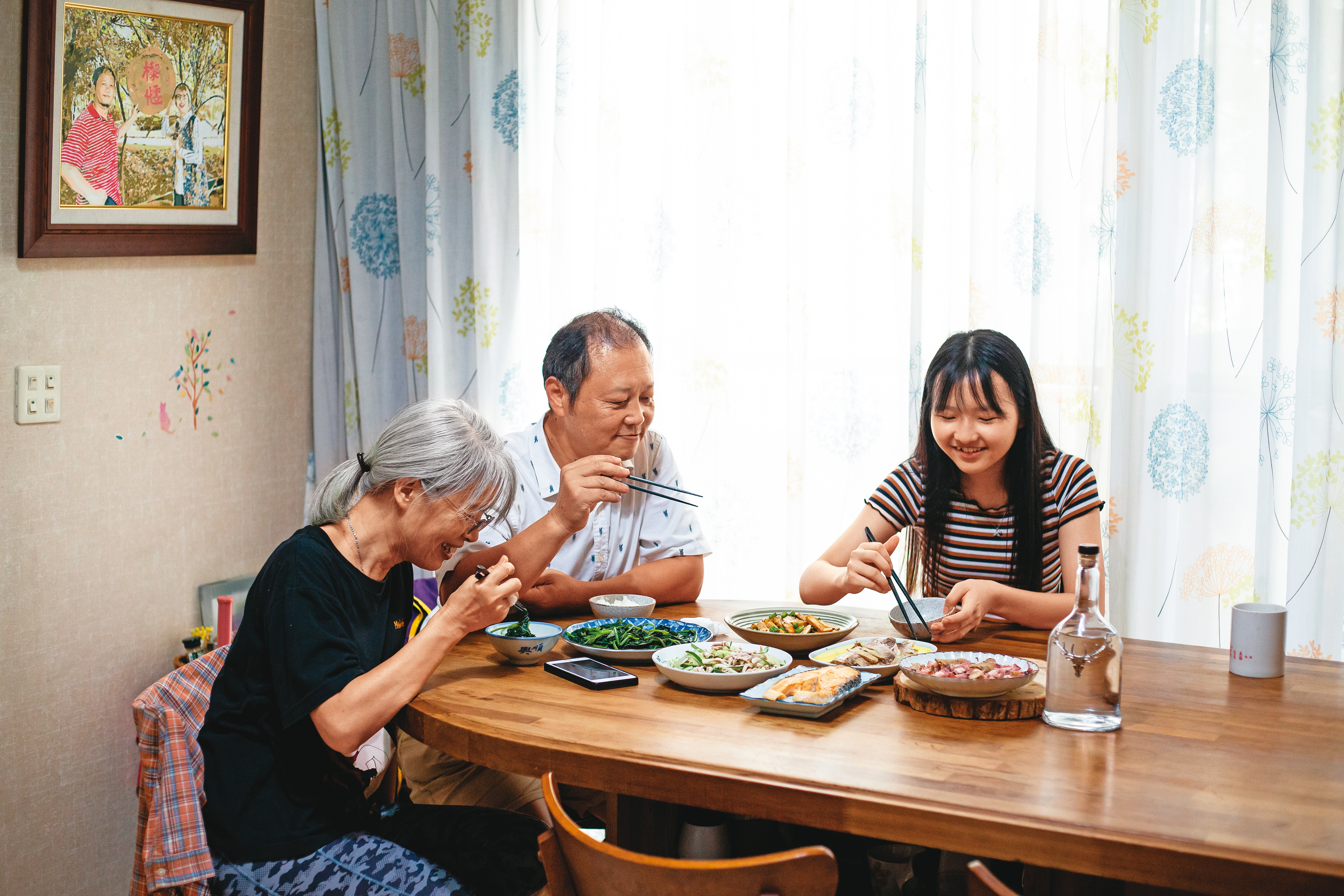萬美麗（左）在外奔波，老公嚴文龍（中）扛起煮飯打理家務之責，小女兒嚴卉聿（右）從小就習慣媽媽會半夜出門接生。