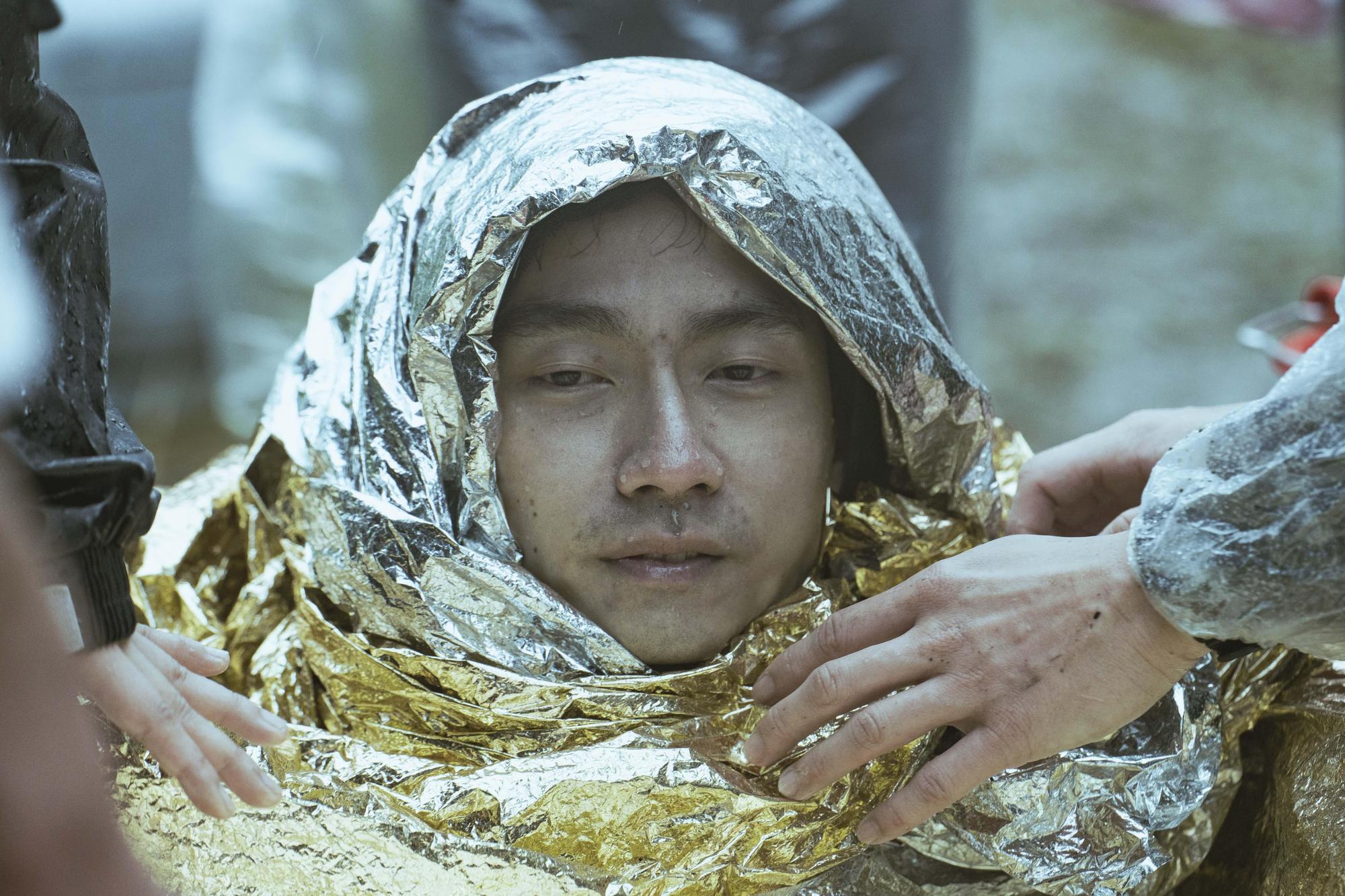大鶴拍戲從水中上來時,渾身發抖,工作人員立即協助讓他恢復溫暖。(金盞花大影業提供)