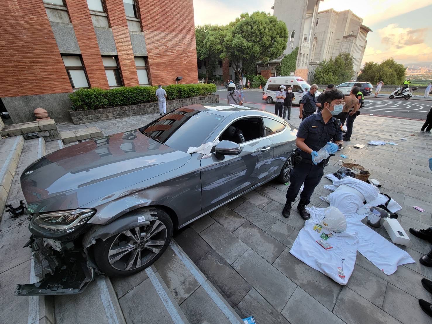 李男的賓士卡在行政大樓前階梯，車體多處毀損。（翻攝畫面）