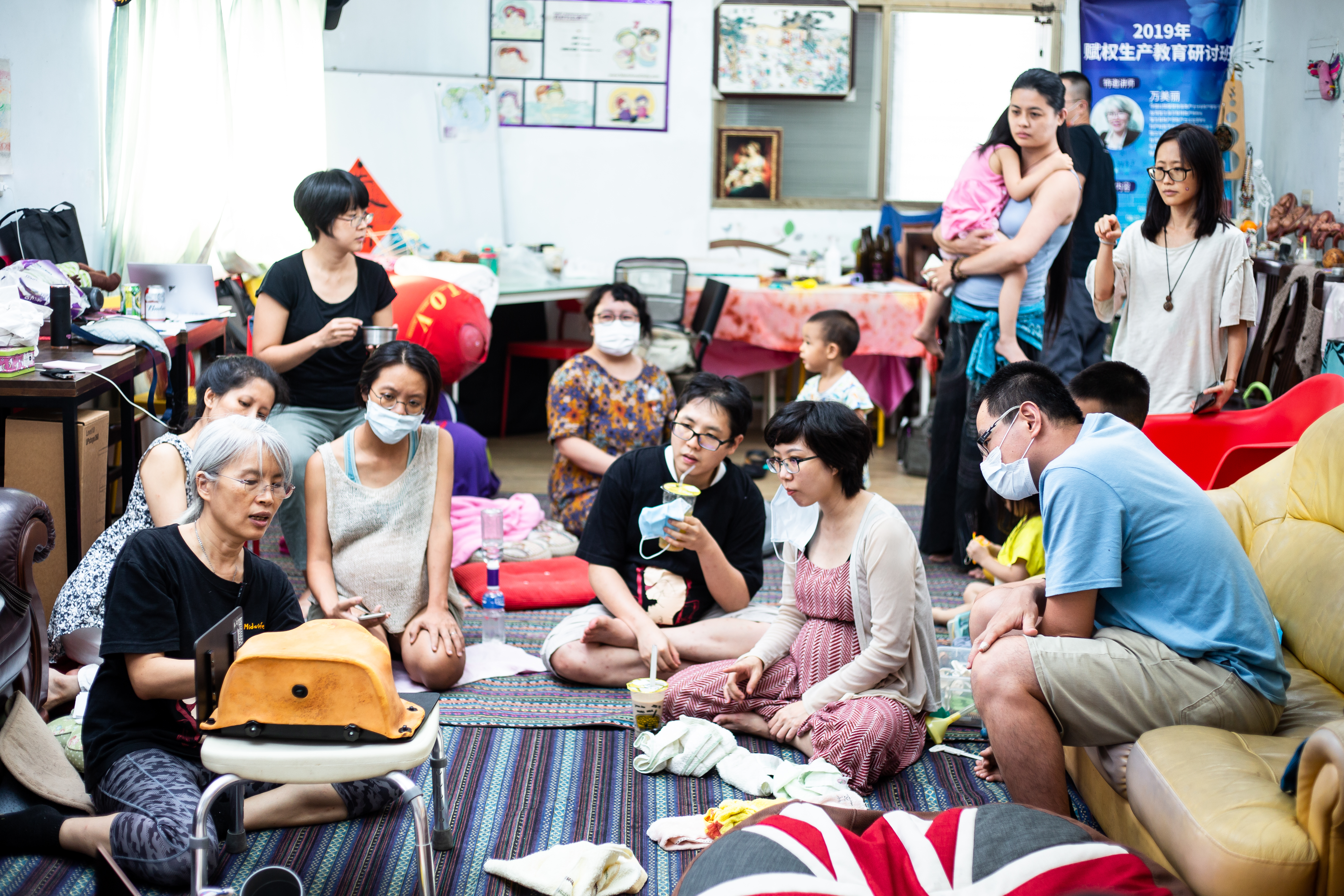 萬美麗（左2）舉辦的賦權生產課程豐富多元，她鼓勵全家一起參加。圖為她示範會陰按摩，預防撕裂傷。