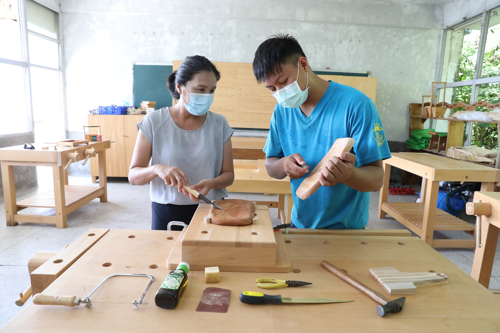 「向陽薪傳木工坊」木工老師仔細教導學員如何逆著木紋進行雕刻。