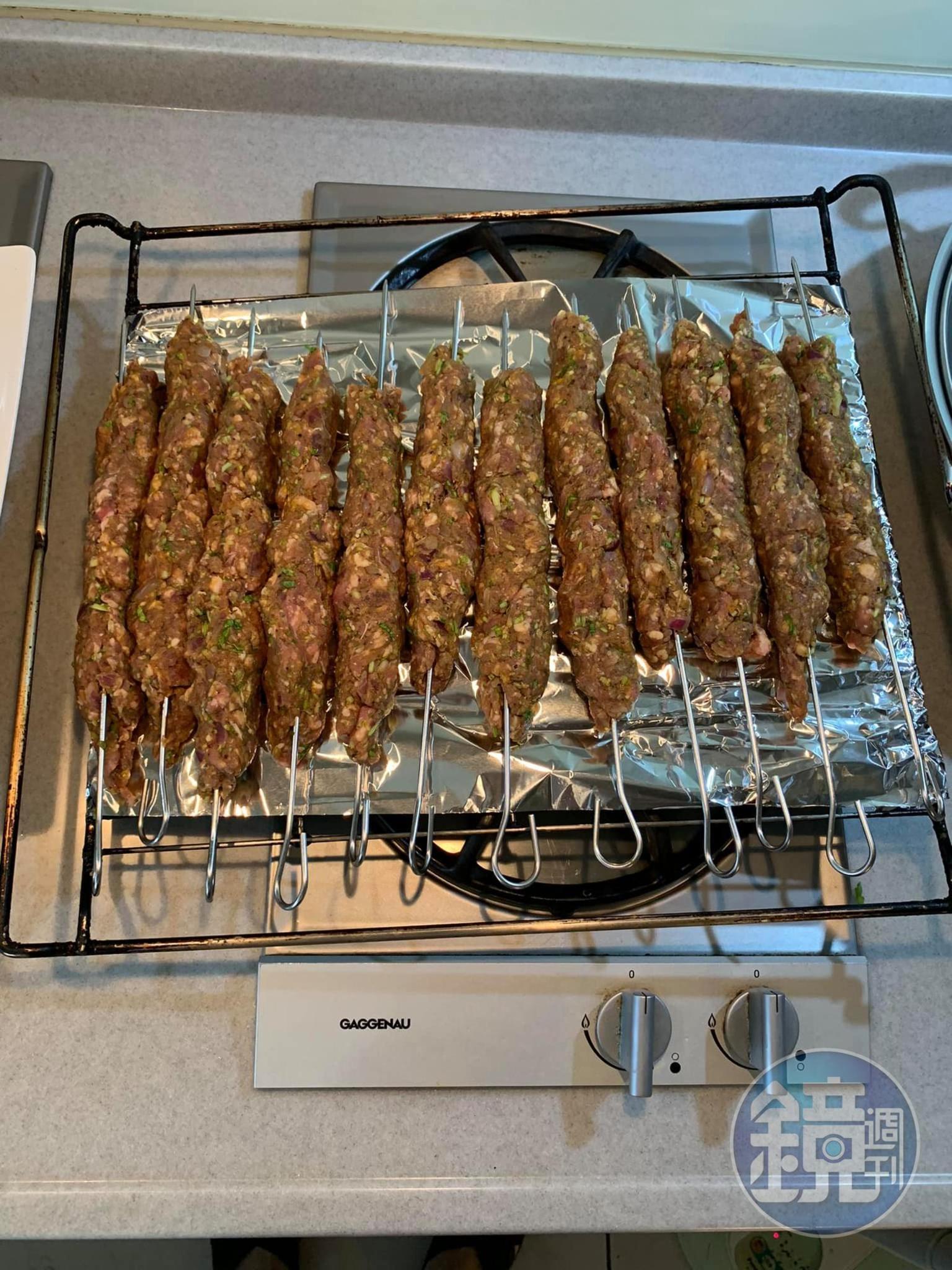 把捏好的肉串放在烤架上。
