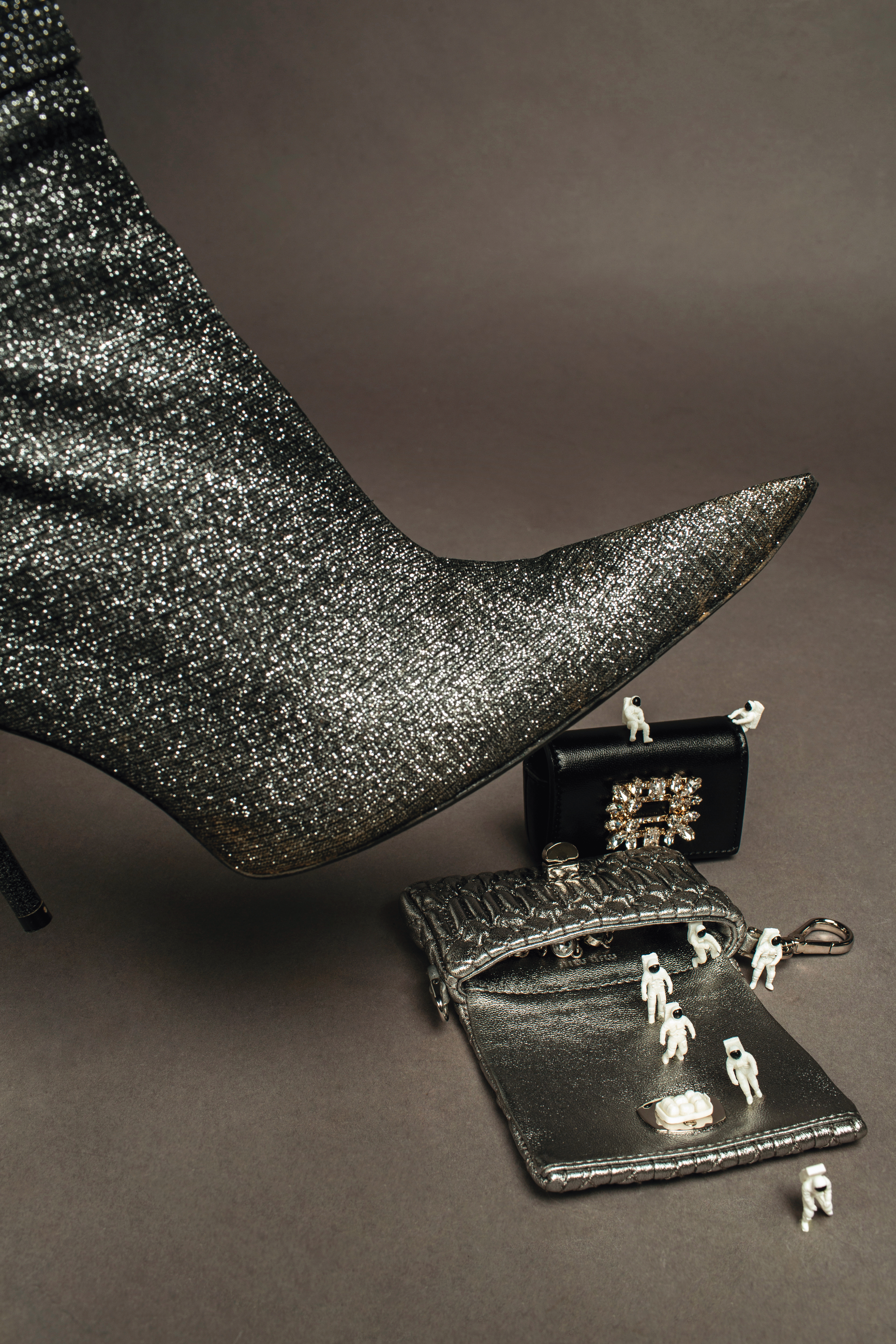 納帕軟皮迷你水晶鍊帶包 NT$21,000 by MIU MIU。Broche迷你包 NT$27,300 by ROGER VIVIER。Essex銀色尖頭長靴 NT$61,550 by BALENCIAGA。
