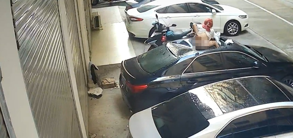 一名穿著上衣加內褲的女子從天而降，將黑色車子上方板金全壓垮。（翻攝自台灣新聞記者聯盟資訊平台臉書）