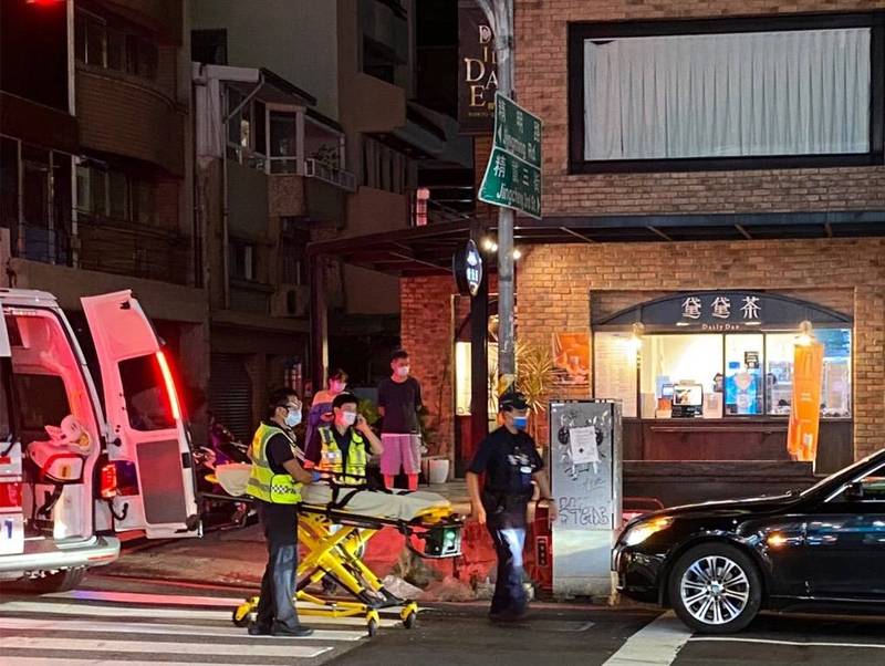 被砍傷的鄭男俯臥在擔架床上，表情痛苦。（讀者提供）