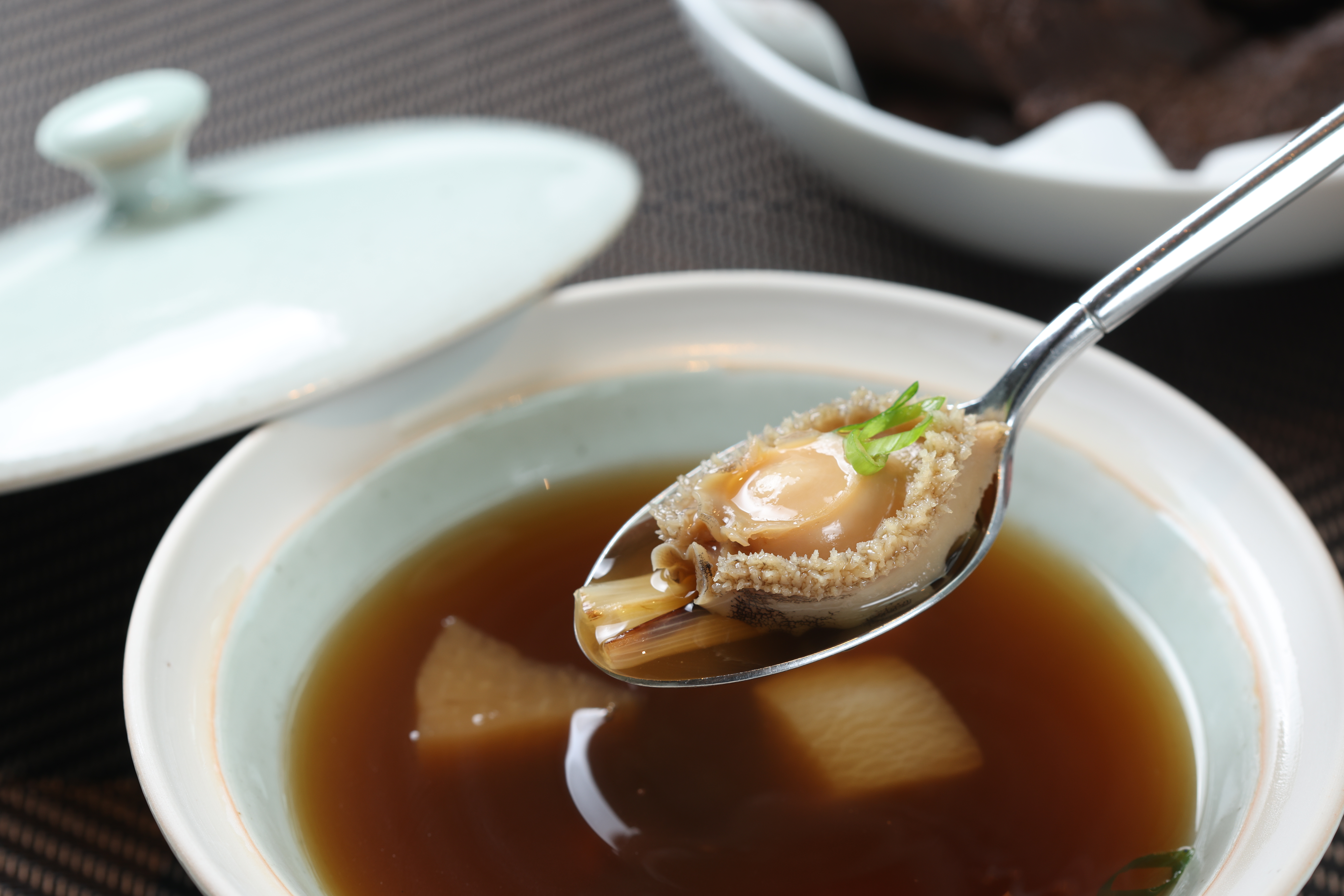 「鮑魚老菜脯法式澄清湯」用老母雞、鮮菇、白蘿蔔細火慢熬16小時，特地加入老菜脯增添回甘滋味。（360元／份）