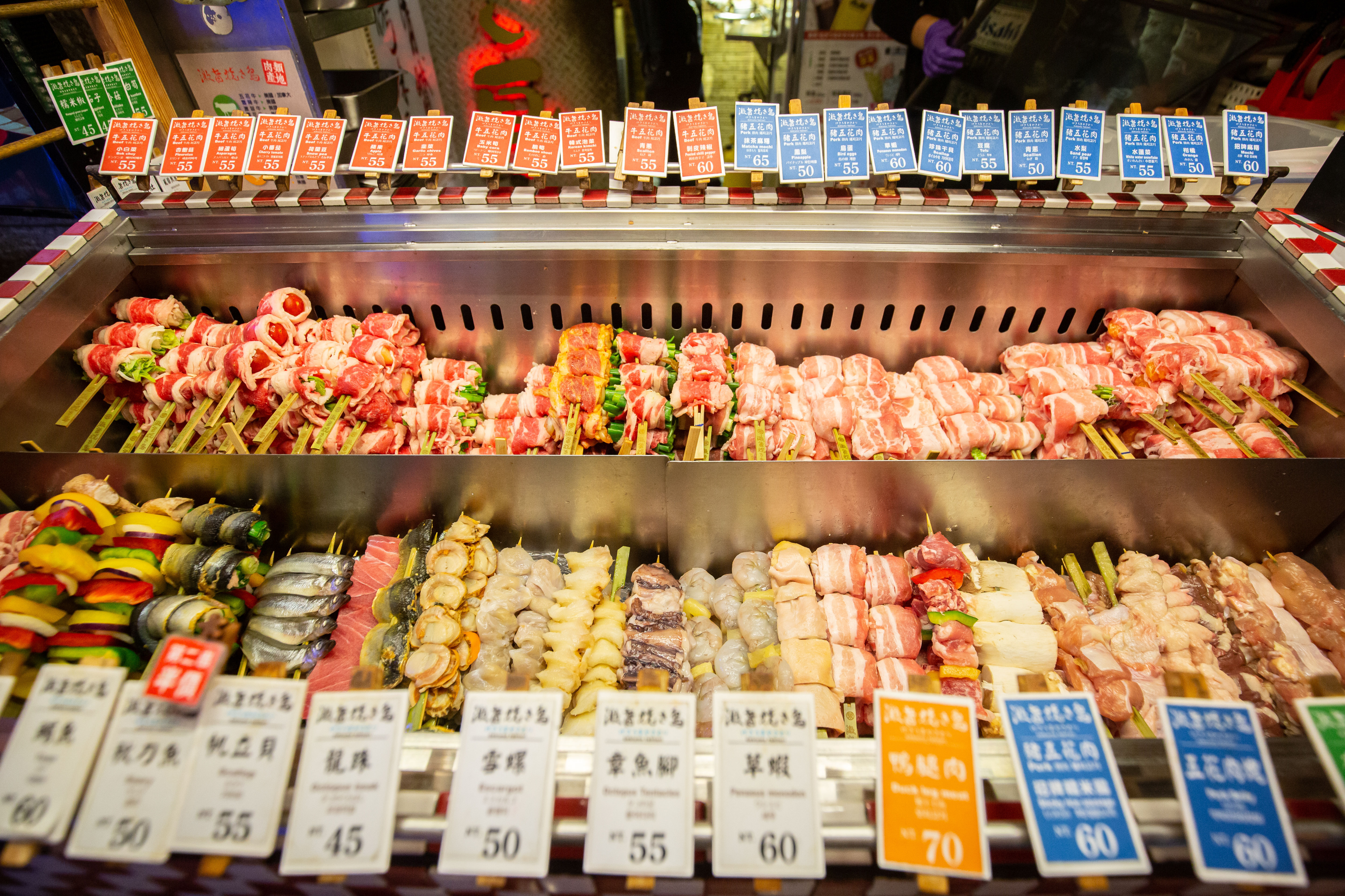 店內陳列上百種串烤，有各式肉類、海鮮，或是包著水果、蔬菜的肉串。