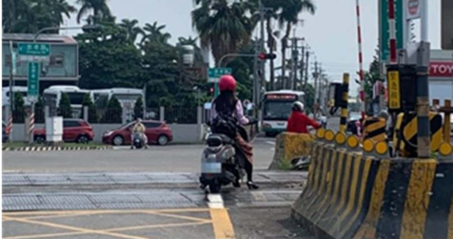 該名女騎士等紅綠燈時，竟停在鐵道上等待，原PO氣炸表示「不就剛好沒火車來？」（翻攝「爆料公社」）