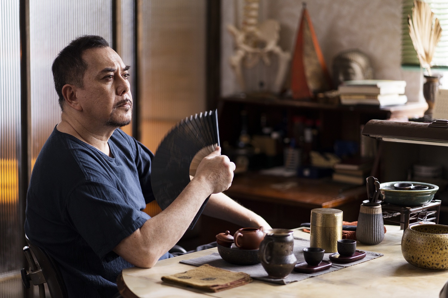 黃秋生飾演推拿師，藉扇子搧風的動作襯托角色狀態。（ 公視提供）