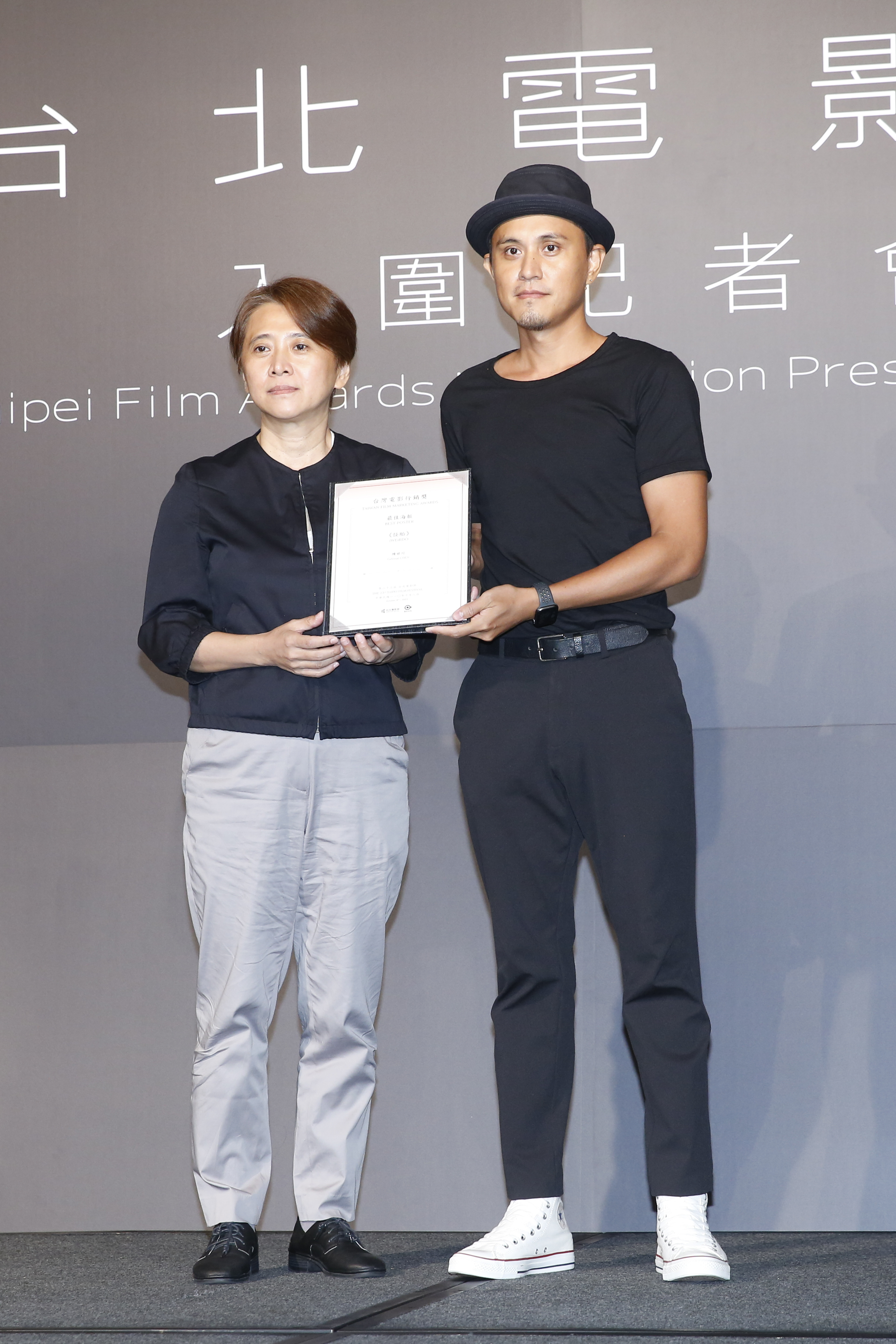 台北電影節總監李亞梅(左)頒獎給「最佳海報」《怪胎》設記者陳世川(右)。