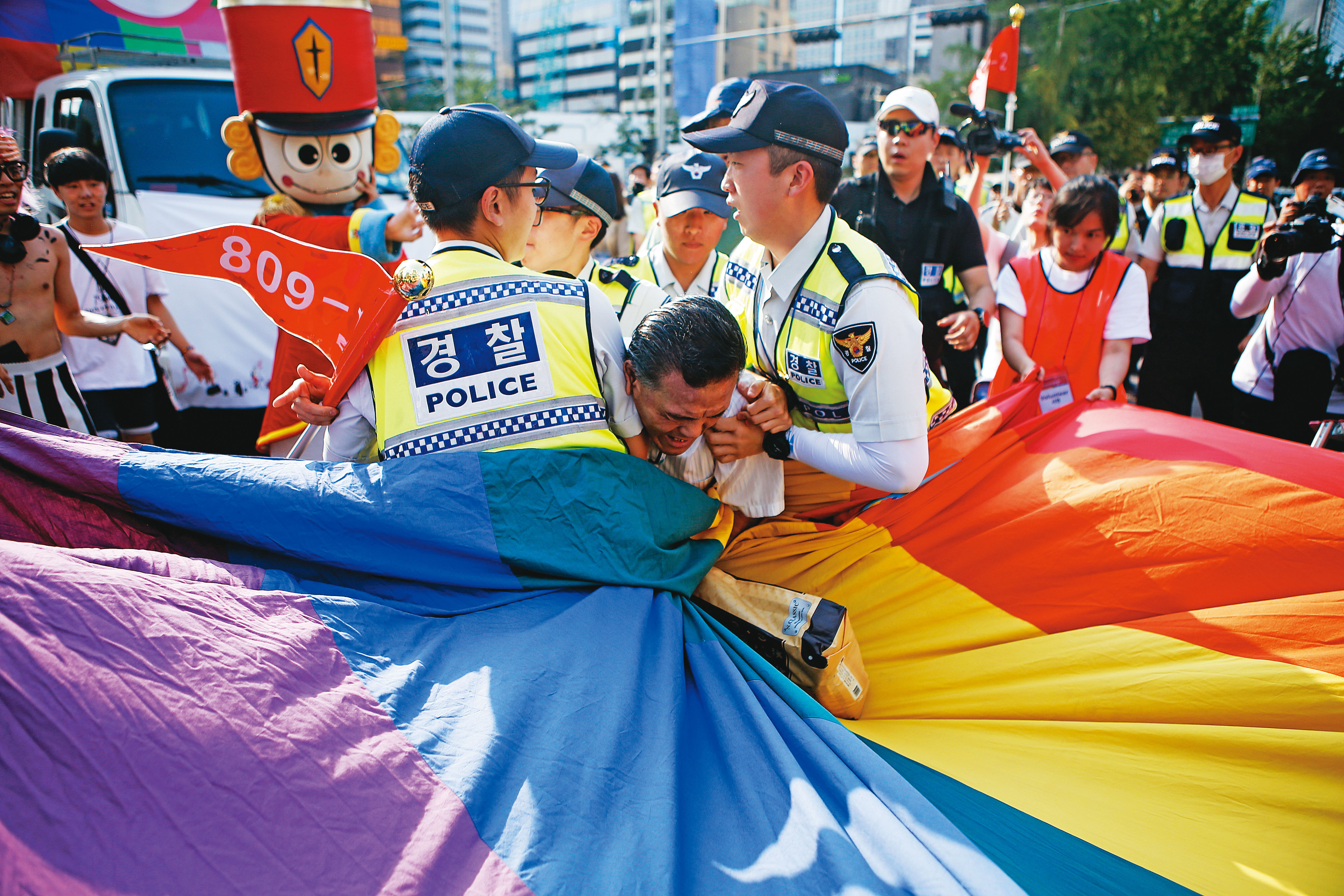 觀念保守的基督徒，是韓國反對同志群體追求性別平等權的主力。圖為2015年的一場同志遊行中，一名基督徒衝進遊行隊伍意圖破壞，遭警察制止。（達志影像）