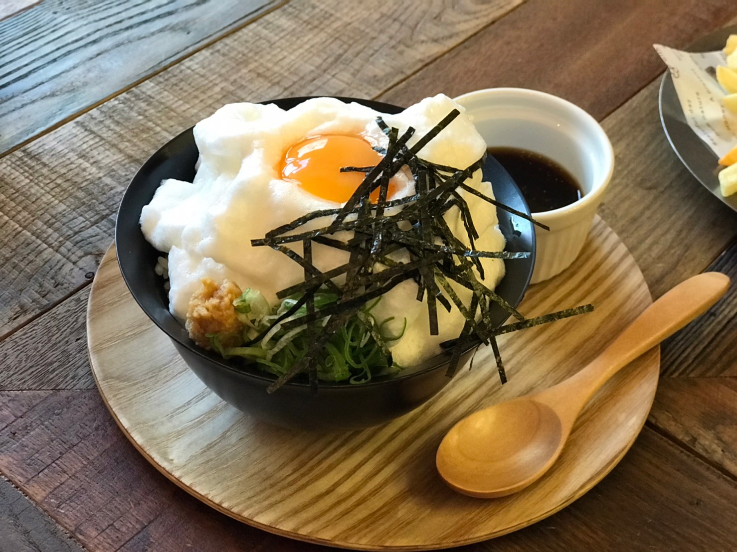 「雲蛋TKG（特製醬油）」以平民美食TKG生蛋拌飯為概念，打發蛋白到有如雲朵蓬鬆，再覆蓋飯上。（100元／份）