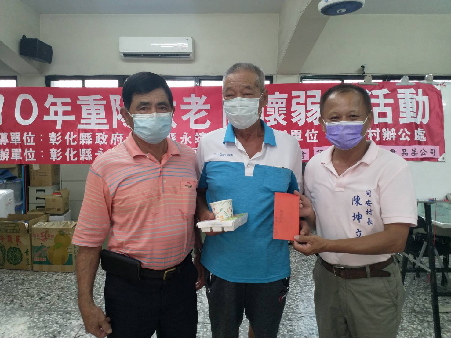 同安村長陳坤立與同安社區邱宗贏理事長送素食餐點給村內長者。（同安村提供）