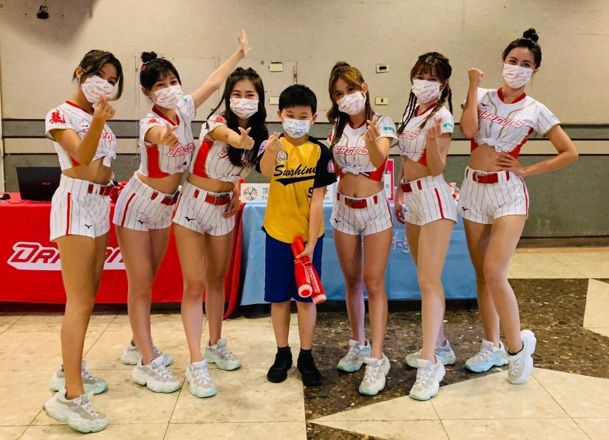  味全龍啦啦隊姐姐們和小宇一起合照，鼓勵他繼續加油。（頂新和德文教基金會提供）