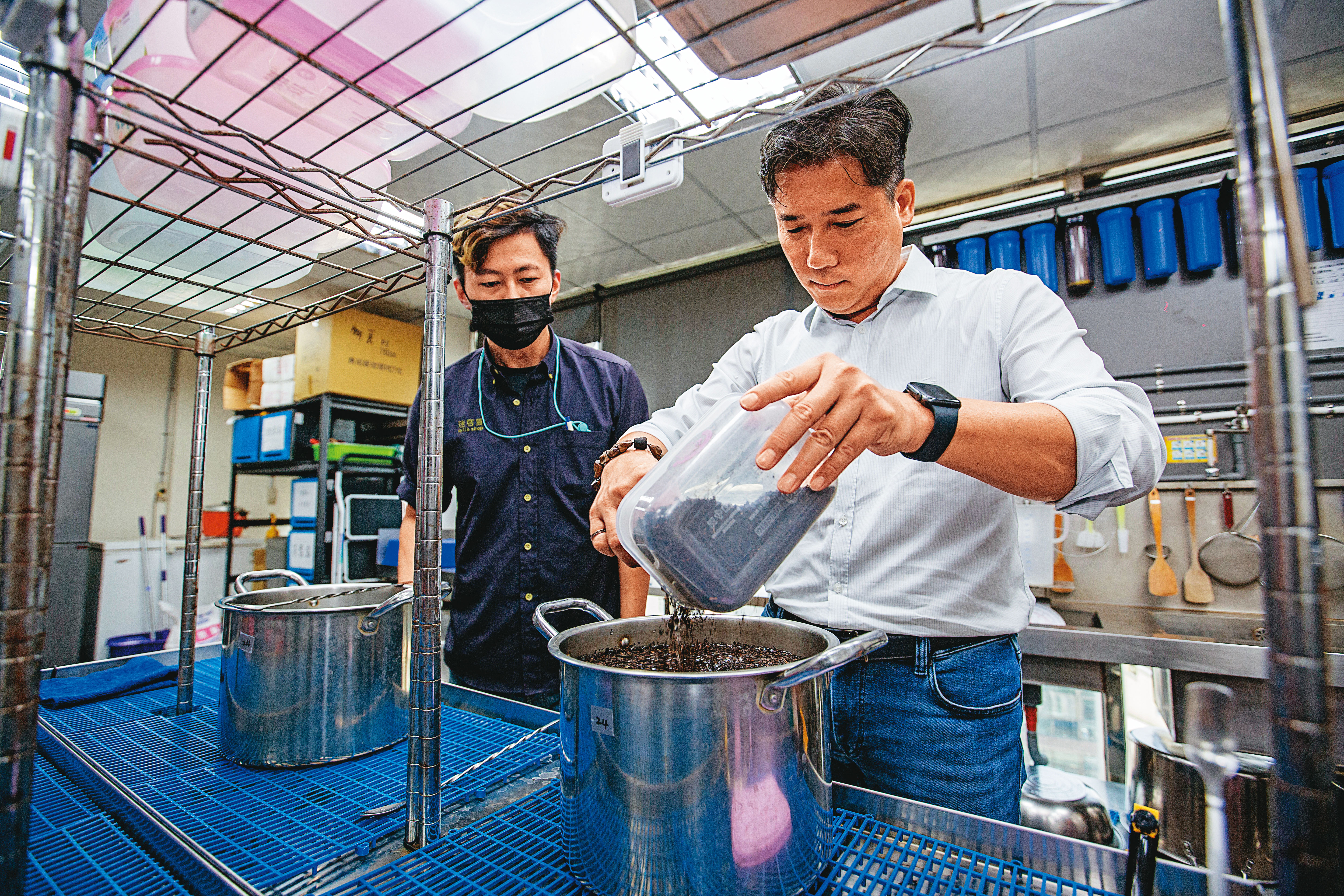 林建燁(右)親自示範迷客夏員工必學的「攪水」,在煮茶時讓茶葉吃水更均勻。