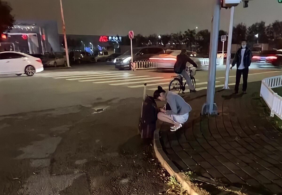 中國海南航空一位空姐因不耐寒冬,縮瑟在路邊發抖的照片引起網友討論。(翻攝微博)