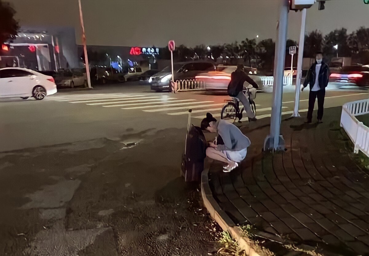 中國海南航空一位空姐因不耐寒冬,縮瑟在路邊發抖的照片引起網友討論。(翻攝微博)