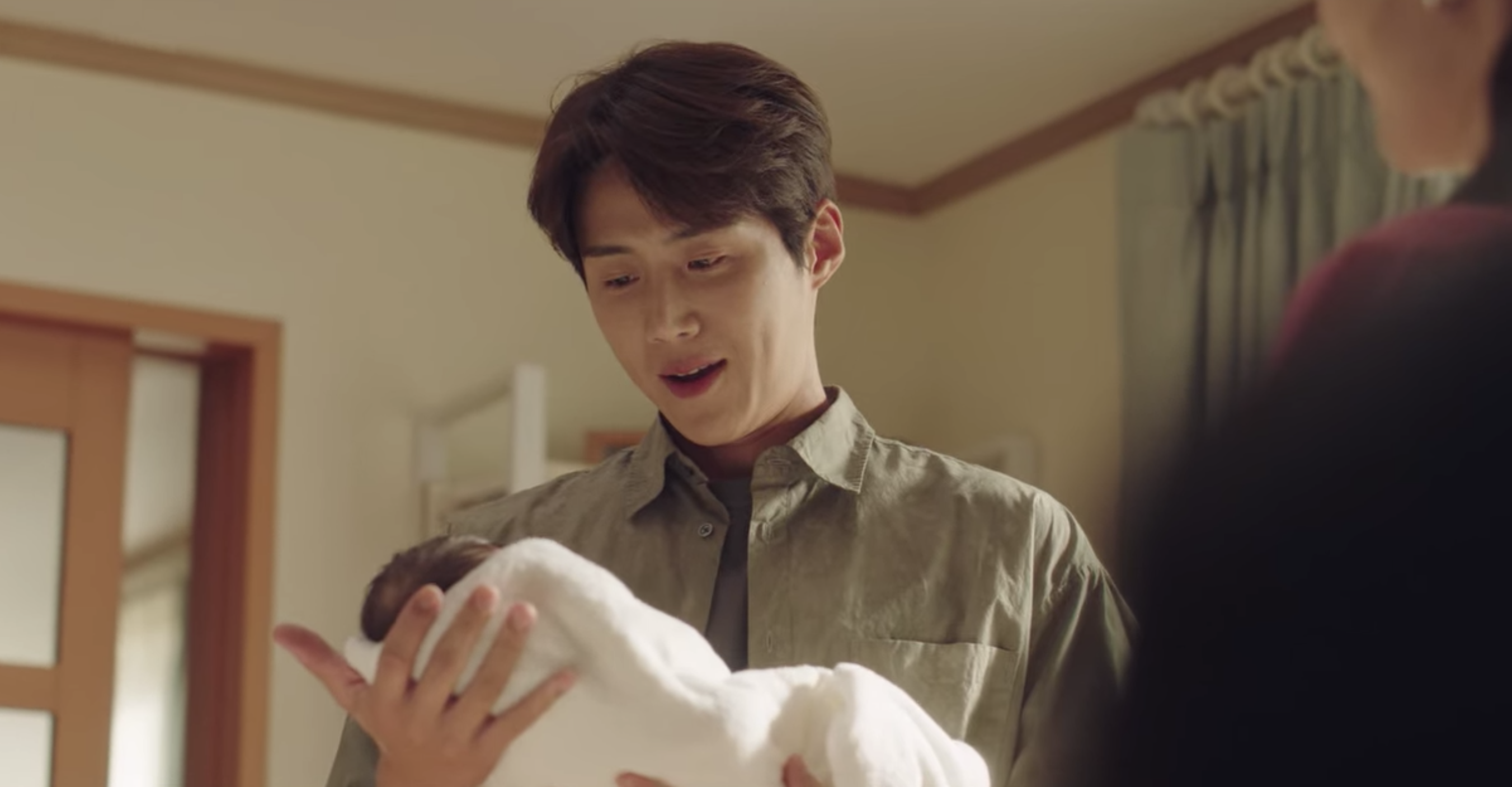 金宣虎小心翼翼抱著小寶寶，現在看來格外諷刺。（翻攝Netflix影片）