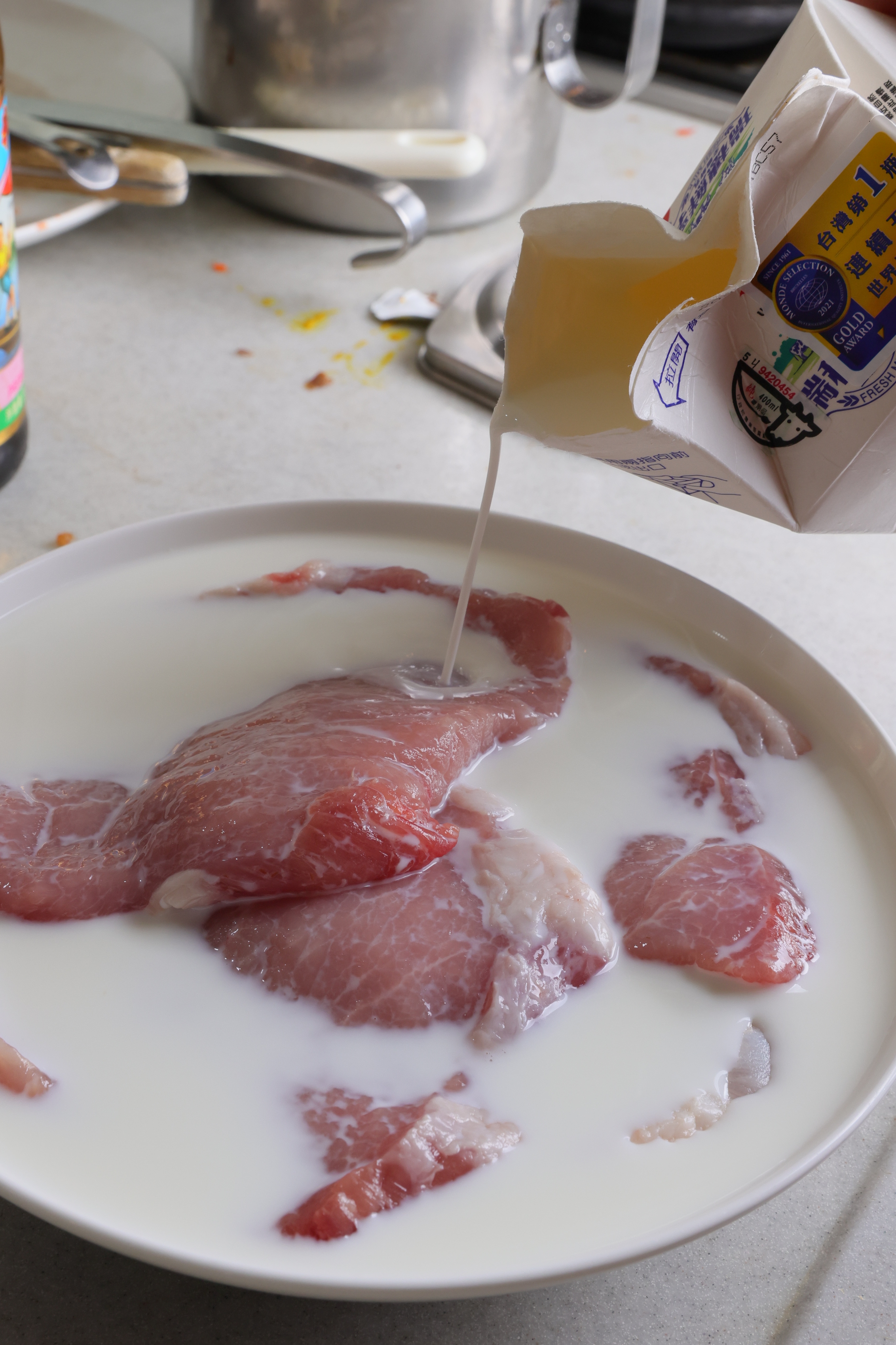 豬排先浸泡牛奶，讓肉質軟嫩。