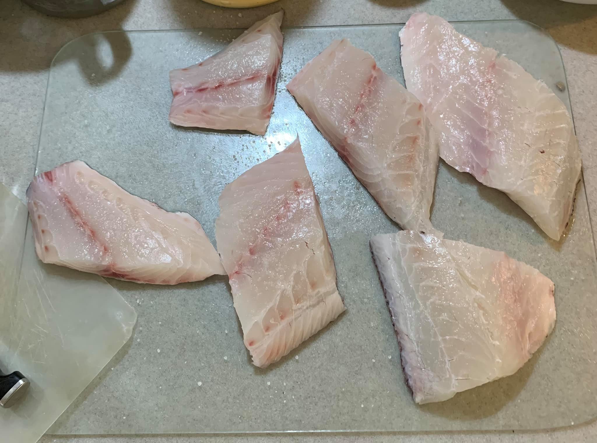 在魚肉上撒鹽入味。
