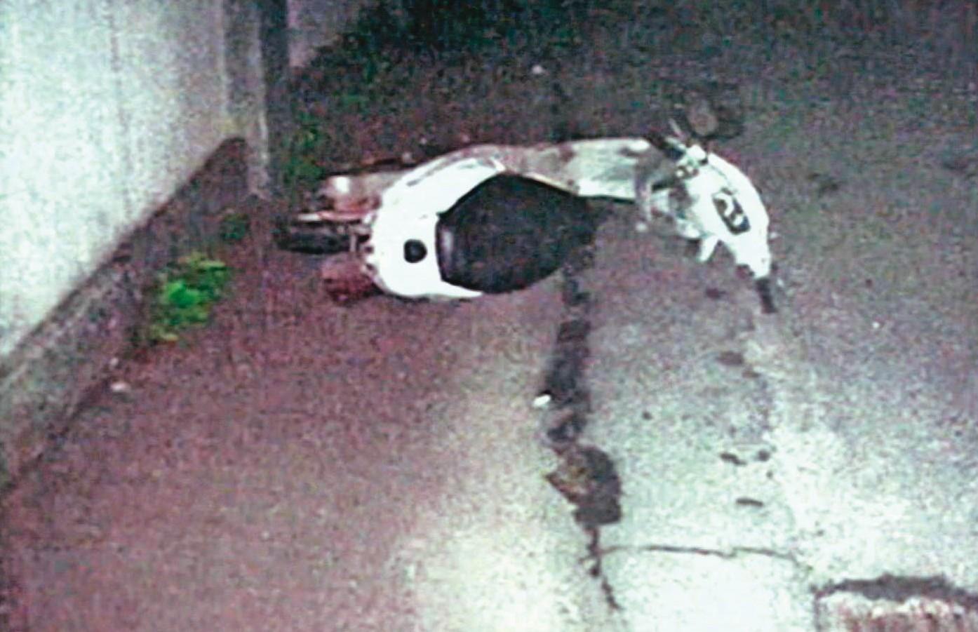 騎機車的死者遭凶手製造假車禍撞死,案發後機車倒在路邊。(翻攝畫面)