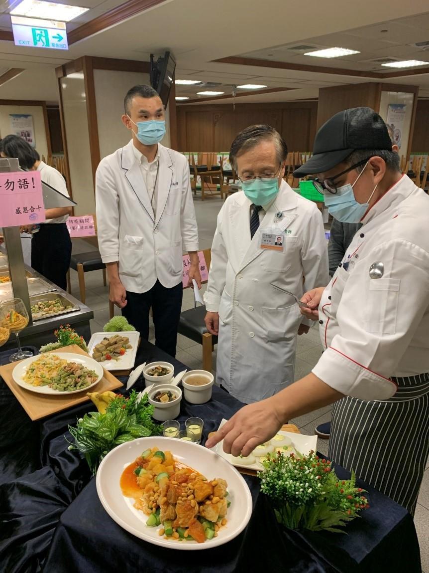 灃食美味革新主廚林奕成(右一)向台中慈濟醫院院長簡守信(中)說明菜色內容。(灃食教育基金會提供)