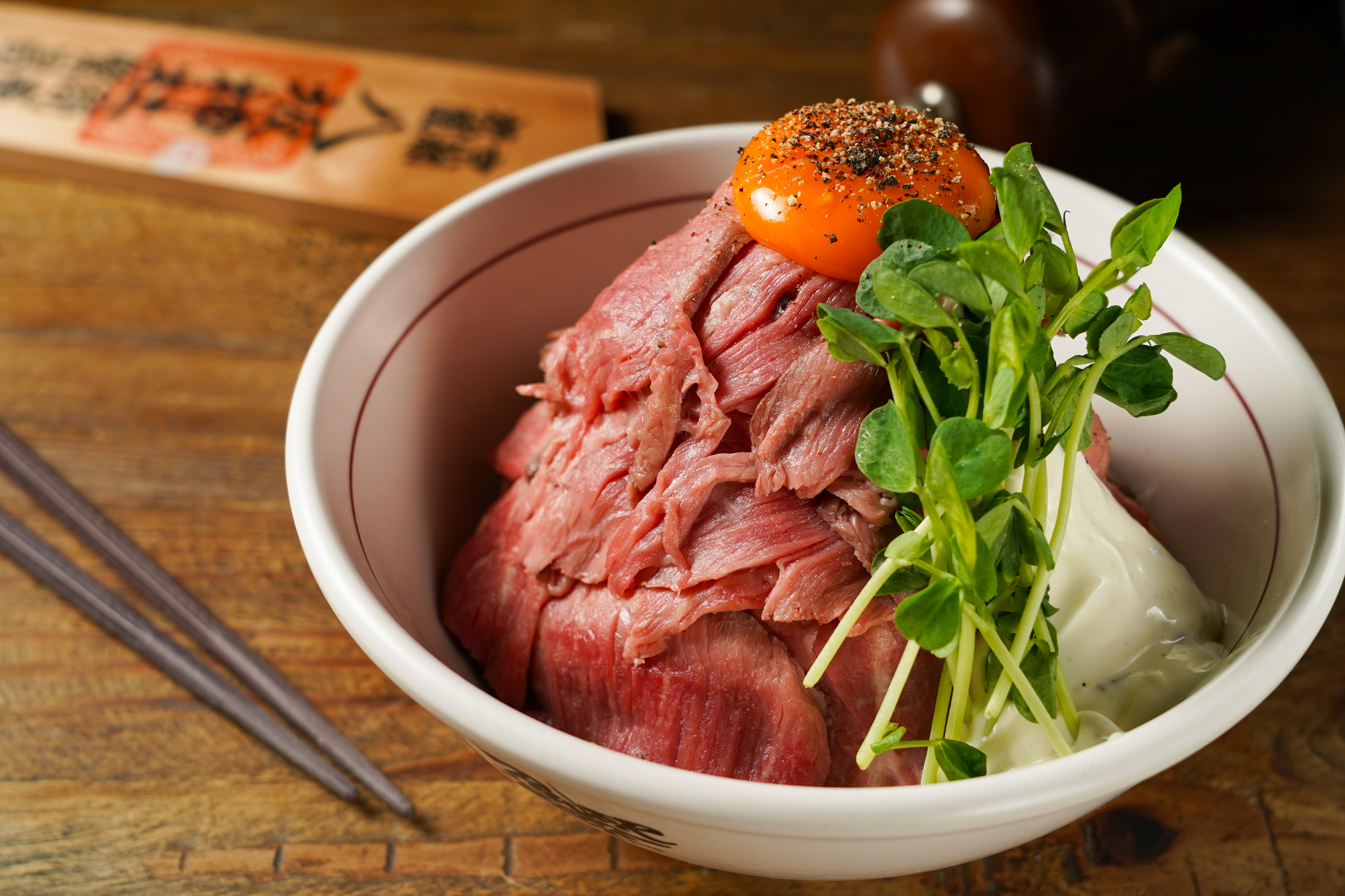 打破「招牌烤牛肉丼」上頭的生蛋黃，腴滑質地裹著嫩肉，讓人一口接一口。（390元／份）