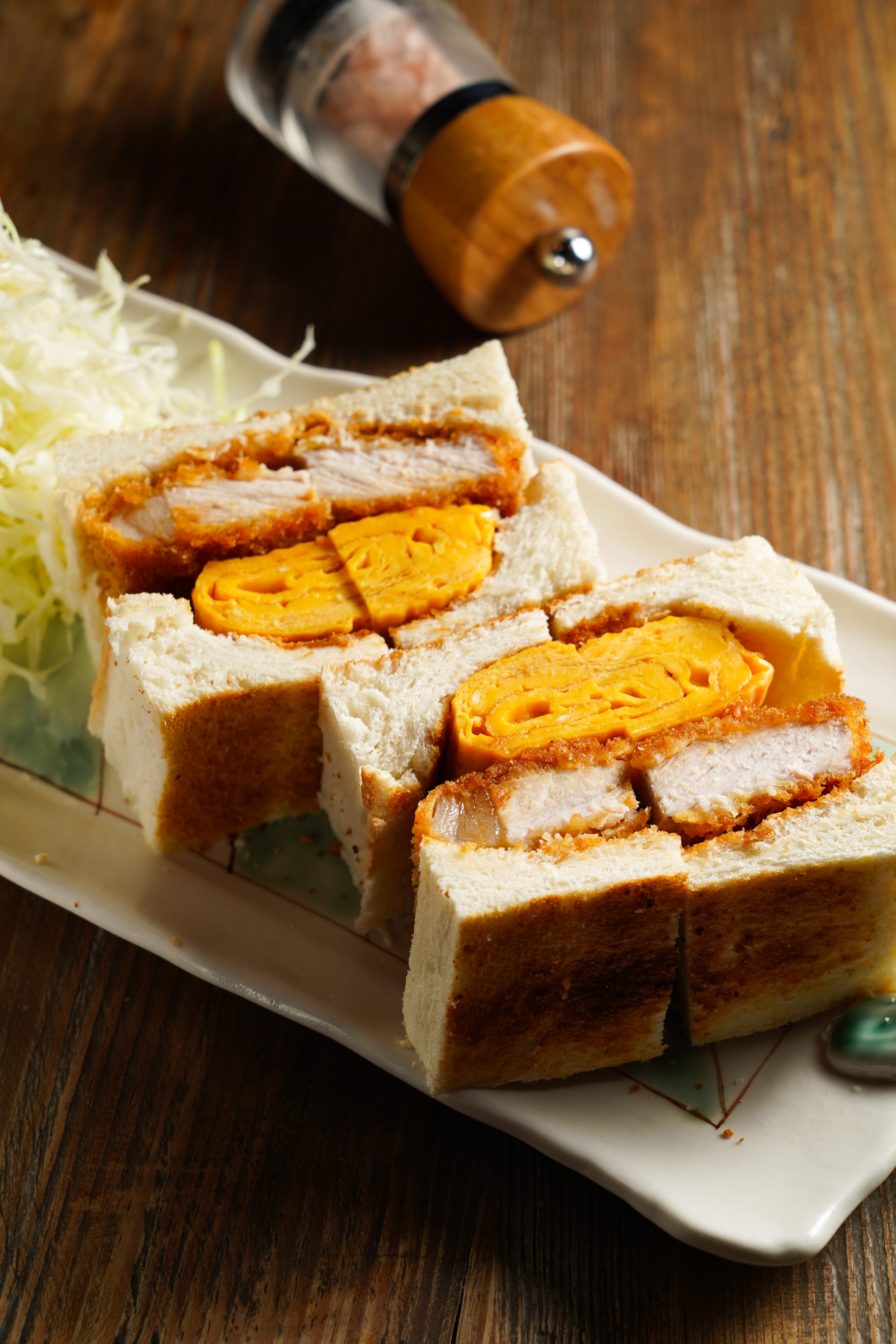 「炸豬排厚玉子三明治」麵衣中的特調香料帶咖哩香氣,配上葉黃素蛋煎成的厚玉子燒,鬆滑不噎人。(380元/份)
