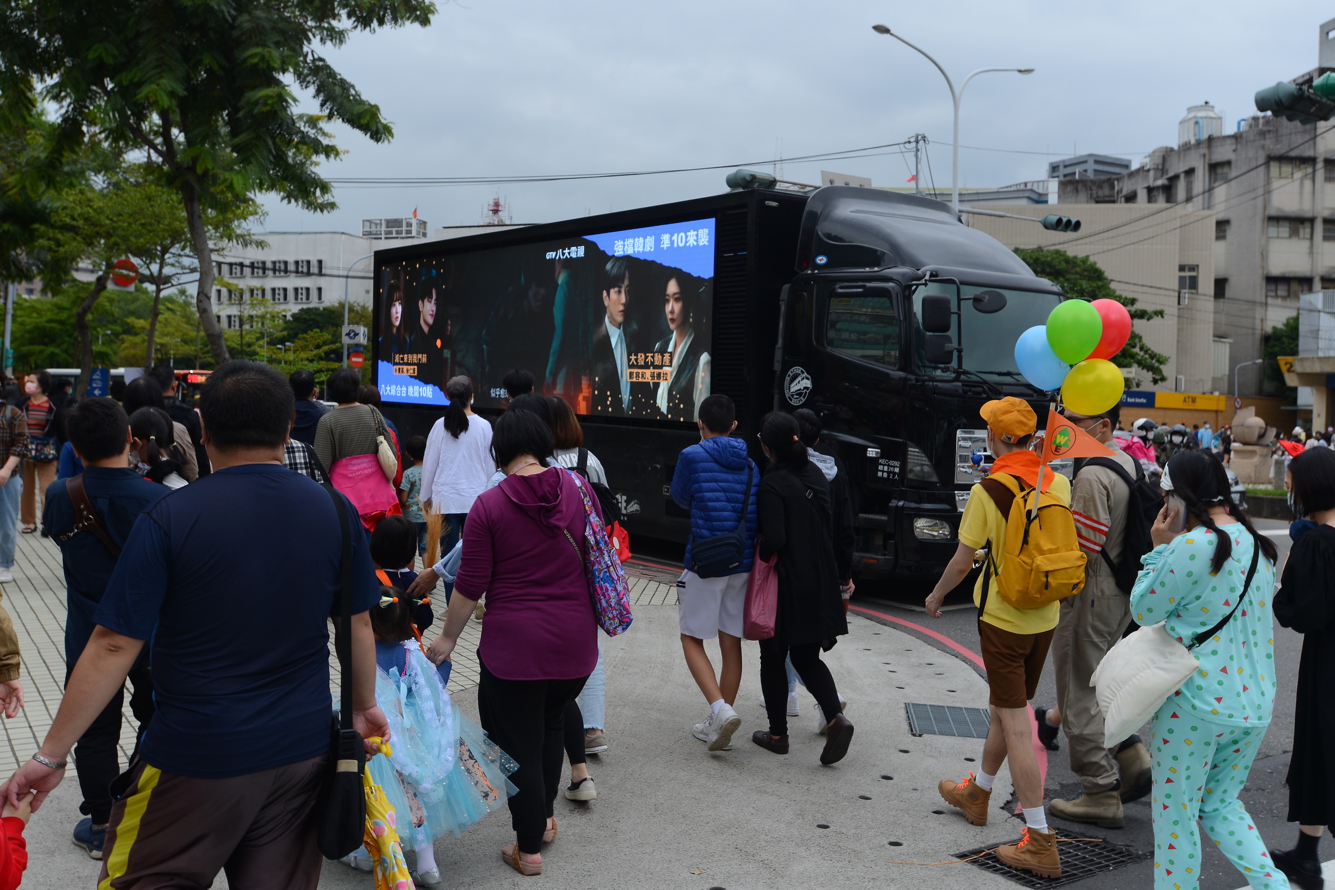 民眾佇足觀賞行動廣告車放送的韓劇預告。(八大提供)