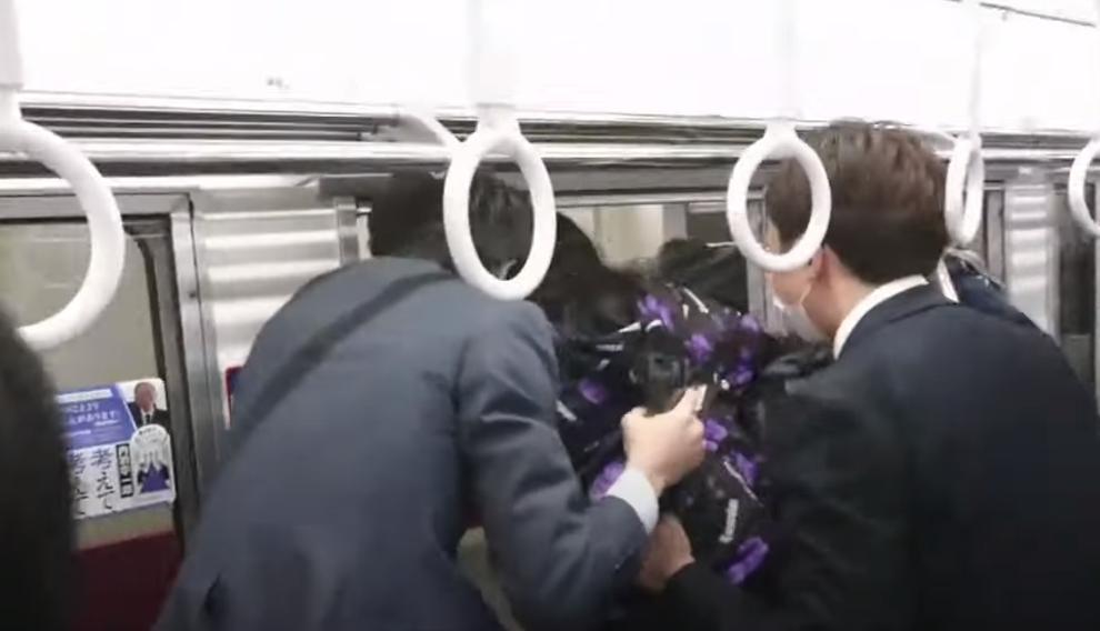 1名男子在行駛中的電車內揮刀並潑灑液體縱火,列車停靠後乘客連忙爬車窗一個接一個逃生。(翻攝推特)