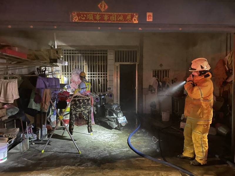 南投縣消防人員就竹山鎮發生火警的民宅拉水線灌救。（消防局提供）