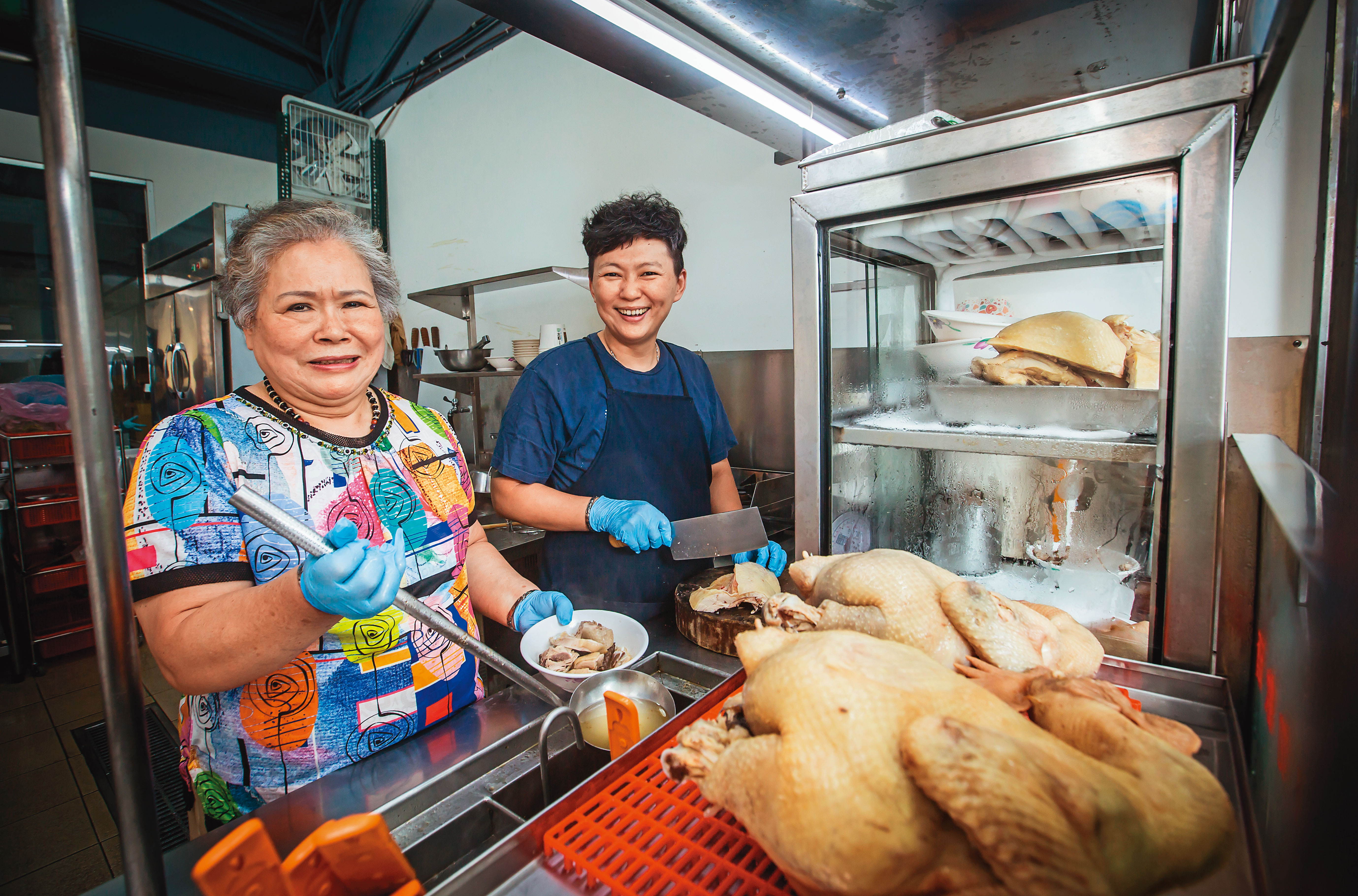 李楊水錦（左）40年前開始在剝皮寮對面擺攤賣麻油雞，女兒李佳美（右）4年前接班，今年在龍山國小附近開起店面。