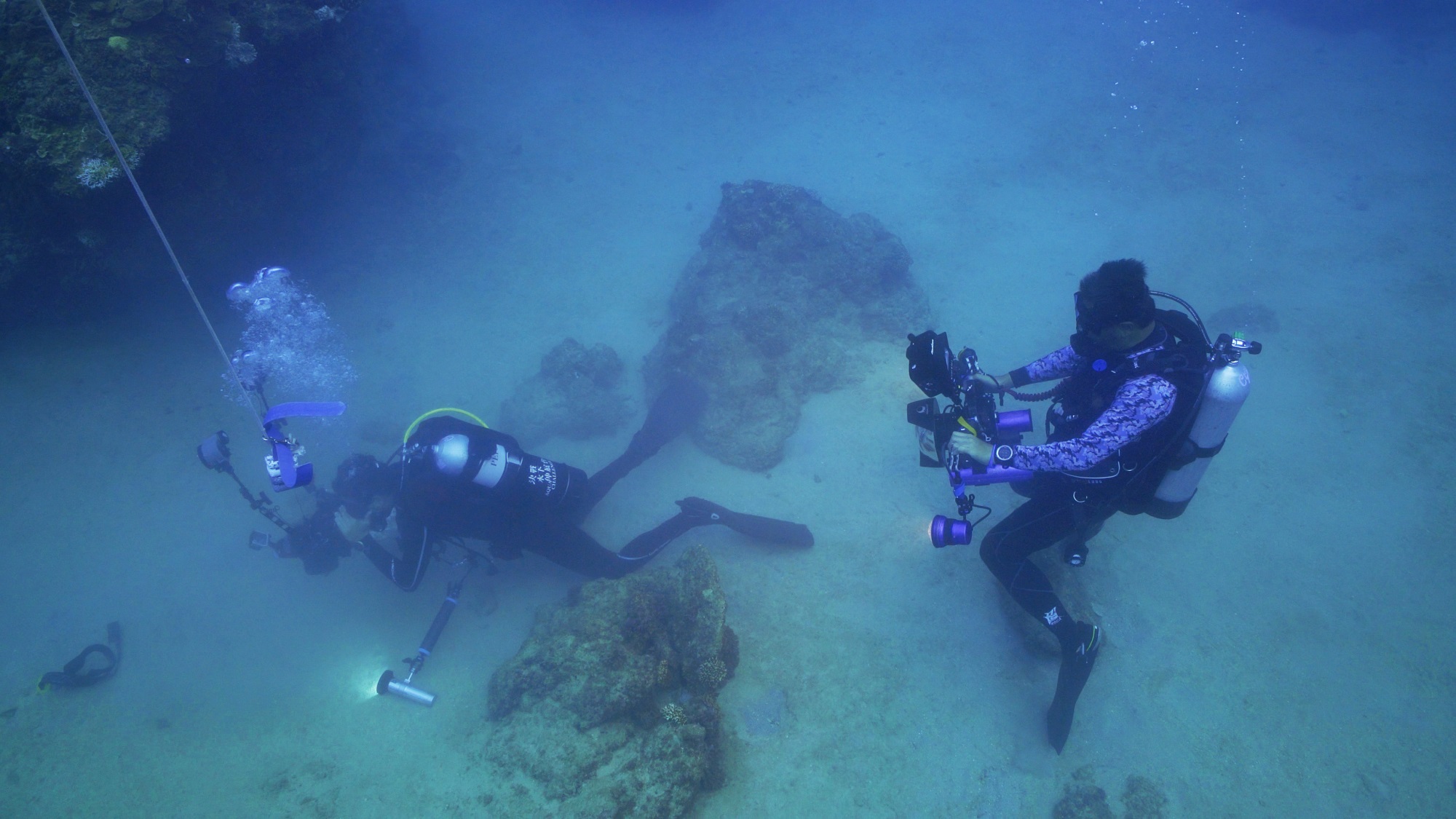 《決戰水下伸展台》製作人兼攝影李景白（右）在水下拍攝畫面時，得保持安全距離，避免干擾參賽者（左）。（《決戰水下伸展台》提供）