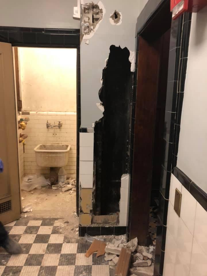 劇院廁所的牆內傳出敲擊求救聲,警方破牆後發現一名男子躲在裡面。(翻攝Syracuse Fire Department臉書)