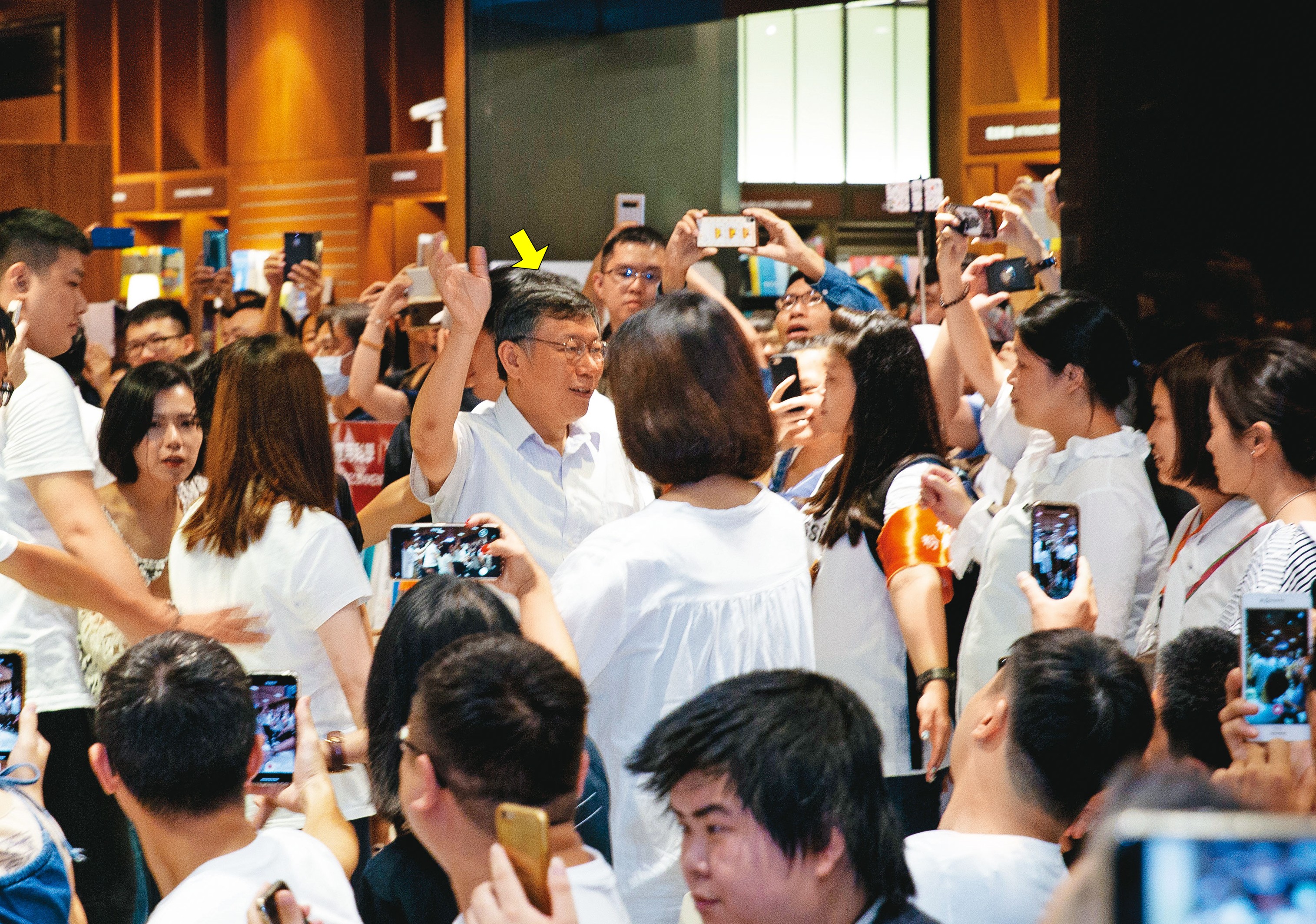 有柯營幕僚曾親眼目睹,陳文鐘常在柯(箭頭處)活動現場擺攤,拿柯的公關書販售賺差價。圖為柯2018新書活動現場。