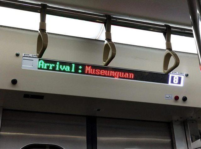 網友拍下台鐵車廂內跑馬燈,顯示下一站為「Museumguan」。(翻攝自臉書爆廢公社二館)