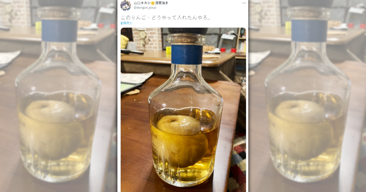 日本網友於推特發文，疑惑這款白蘭地酒瓶中的大蘋果是如何塞入，引發日台兩邊網友熱議。（翻攝推特＠donguri_soup）