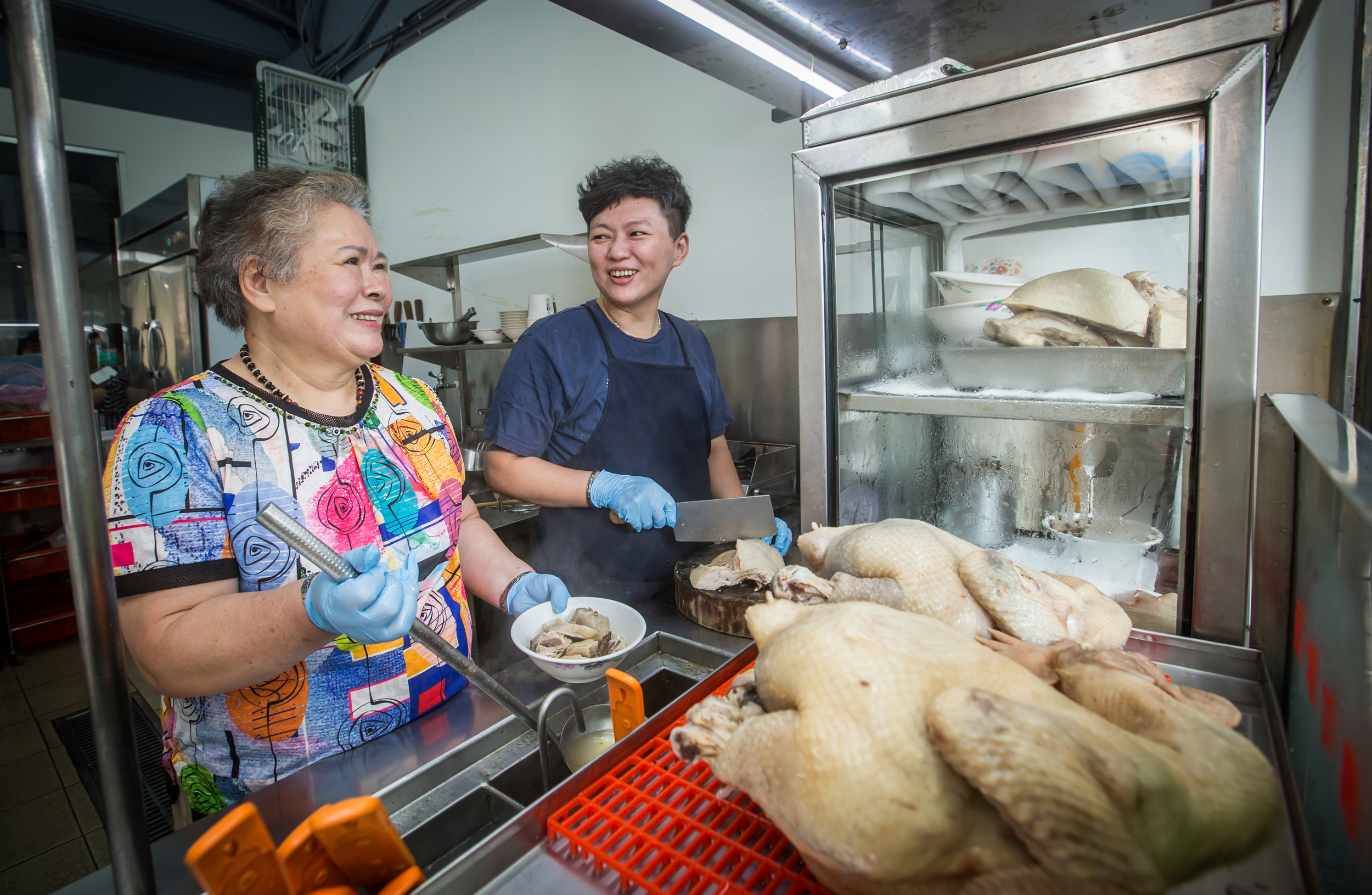 李楊水錦（左）40年前開始在剝皮寮對面擺攤賣麻油雞，女兒李佳美（右）4年前接班，今年在龍山國小附近開起店面。