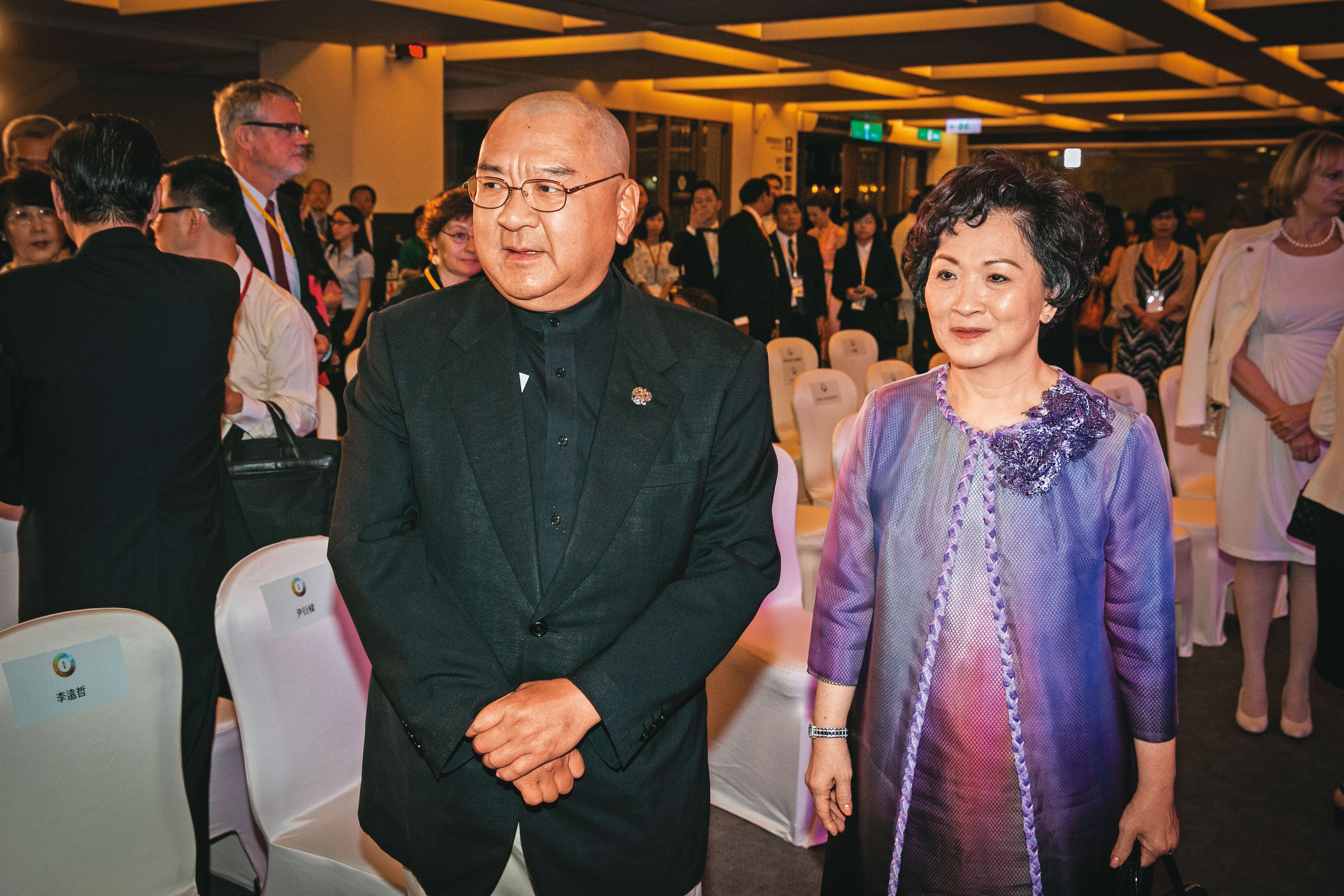 尹衍樑(左)身價逾千億元,育有一對子女,他經常與妻子王綺帆(右)出席重要活動。