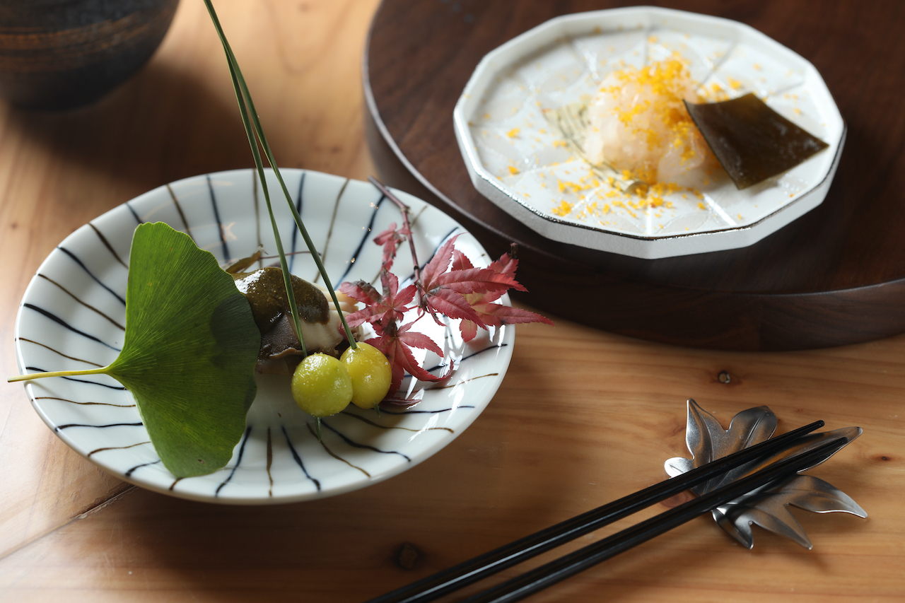 小皿裡的「靜岡產 黑鮑魚 肝醬油 蕪菁 吹き寄せ 」（左）風味濃郁，口感彈潤；「富山產 白蝦 磯雪昆布 烏魚子 」（右），集結海水和醃漬物的多重鮮味，像海潮拍打舌蕾。（皆9,800元套餐菜色）