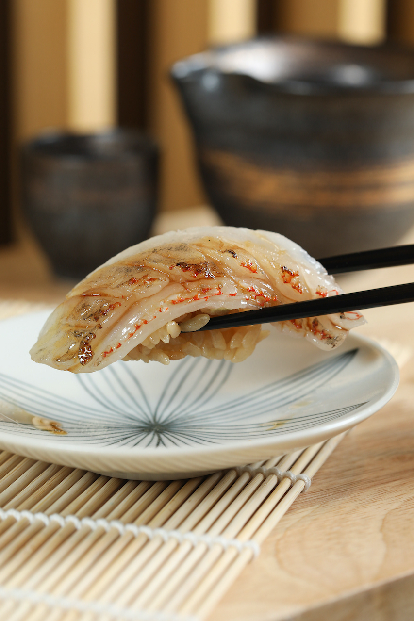 海鹽輕醃過的「喜知次炙燒」質地纖細，香醇醋飯勾出甜味。（9,800元套餐菜色）