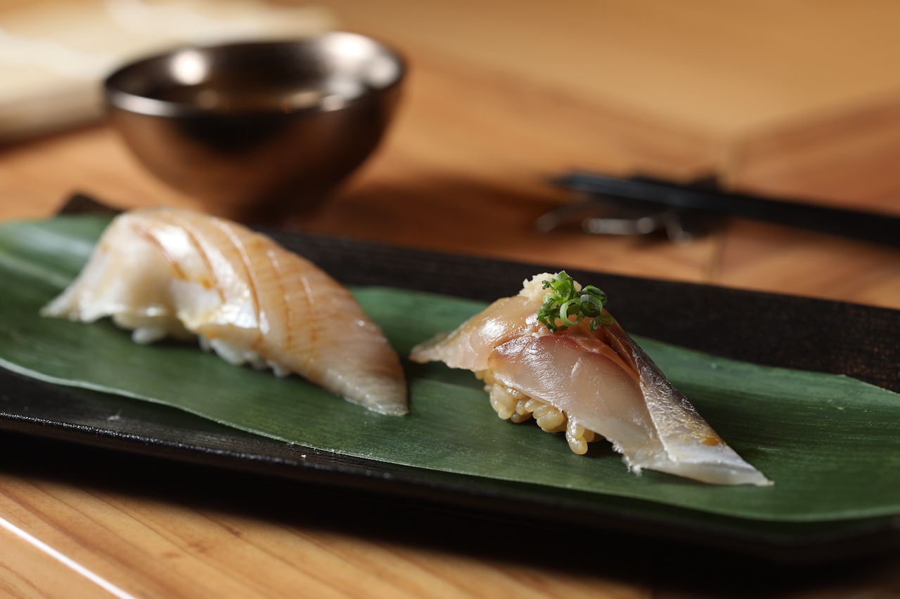 浸泡鹽水熟成的亮皮魚「竹莢魚」（右）和白肉魚「鰤魚」（左），風味濃縮，肉質彈潤。（皆9,800元套餐菜色）