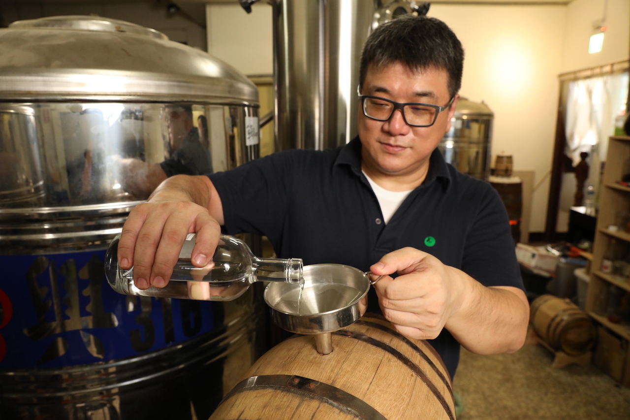 步驟4：把蒸餾後的琴酒烈酒，注進木桶裡熟成上色。