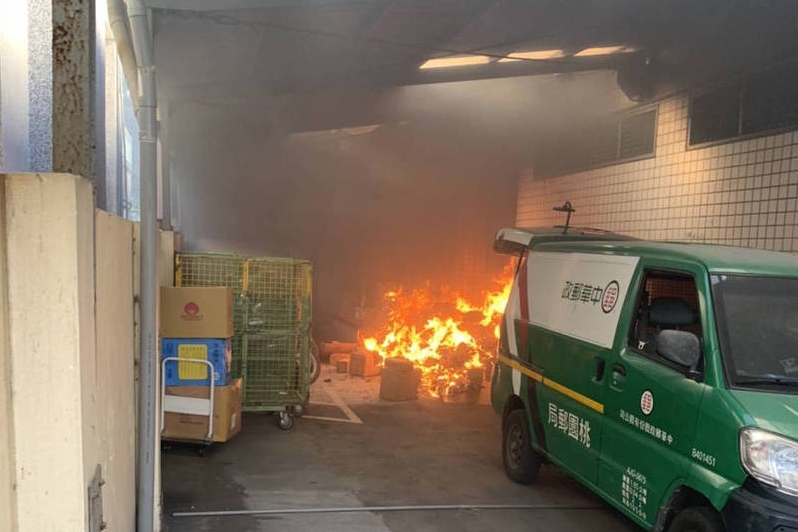新屋郵局上午發生火警，雖無人傷亡，但車道旁的包裹全燒壞。（翻攝畫面）