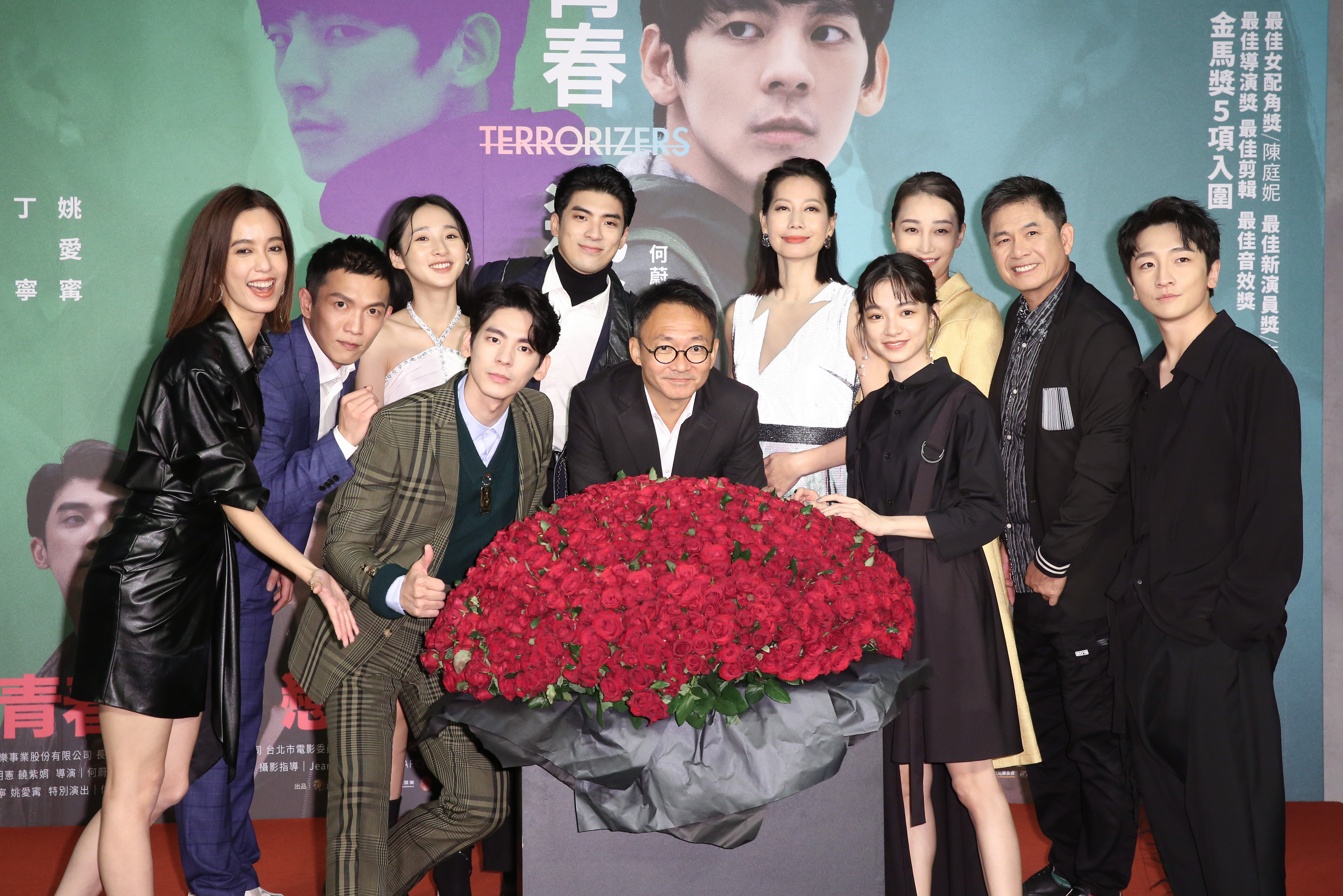導演何蔚庭(前排中)新作《青春弒戀》,由林柏宏、李沐、陳庭妮、林哲熹、丁寧、姚愛寗主演,首映典禮上有象徵浪漫愛情的「999朵紅玫瑰」花束。